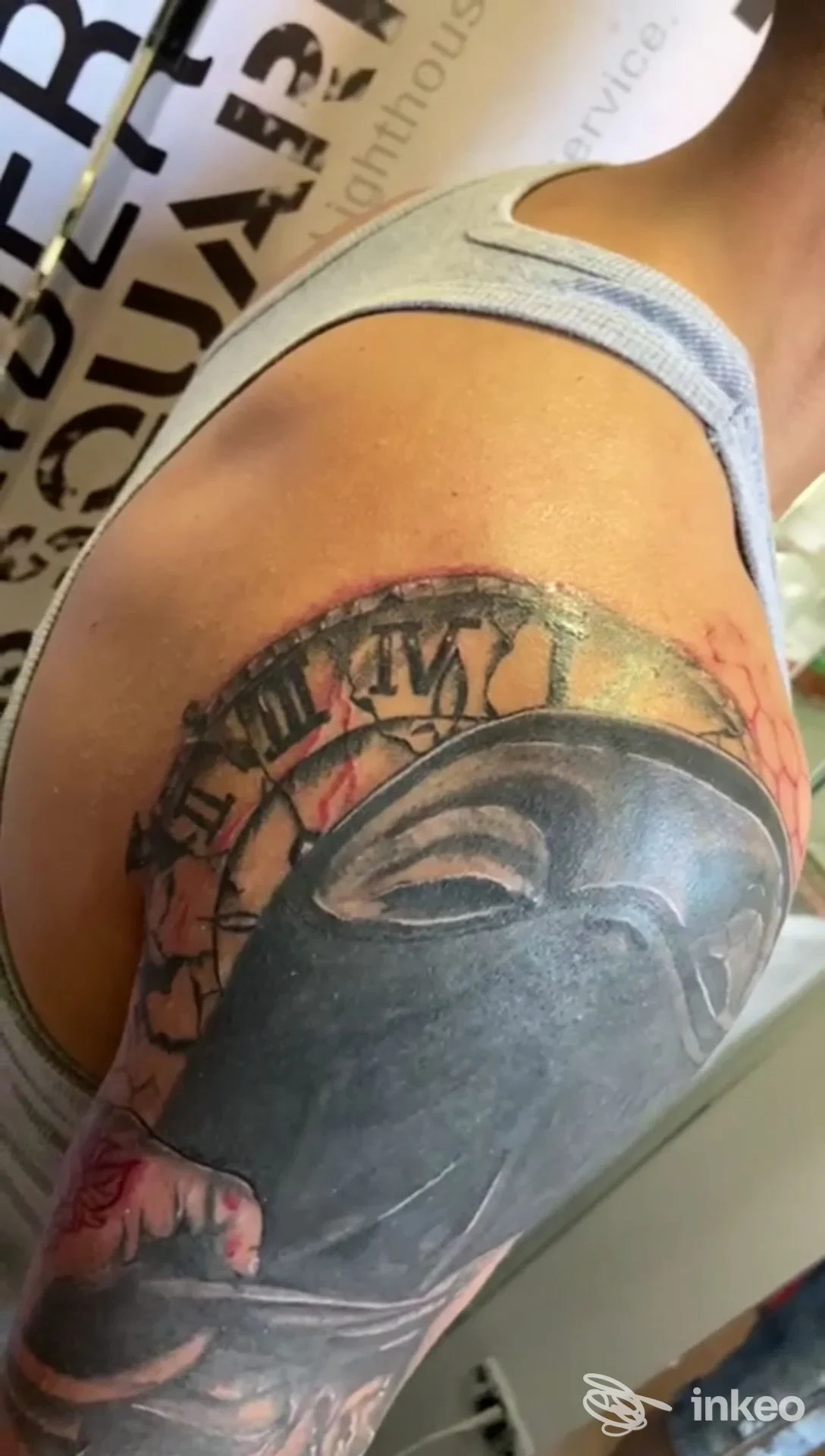 Tatuaggio colorato sul braccio presso la spalla, visibile in primo piano senza volto della persona.