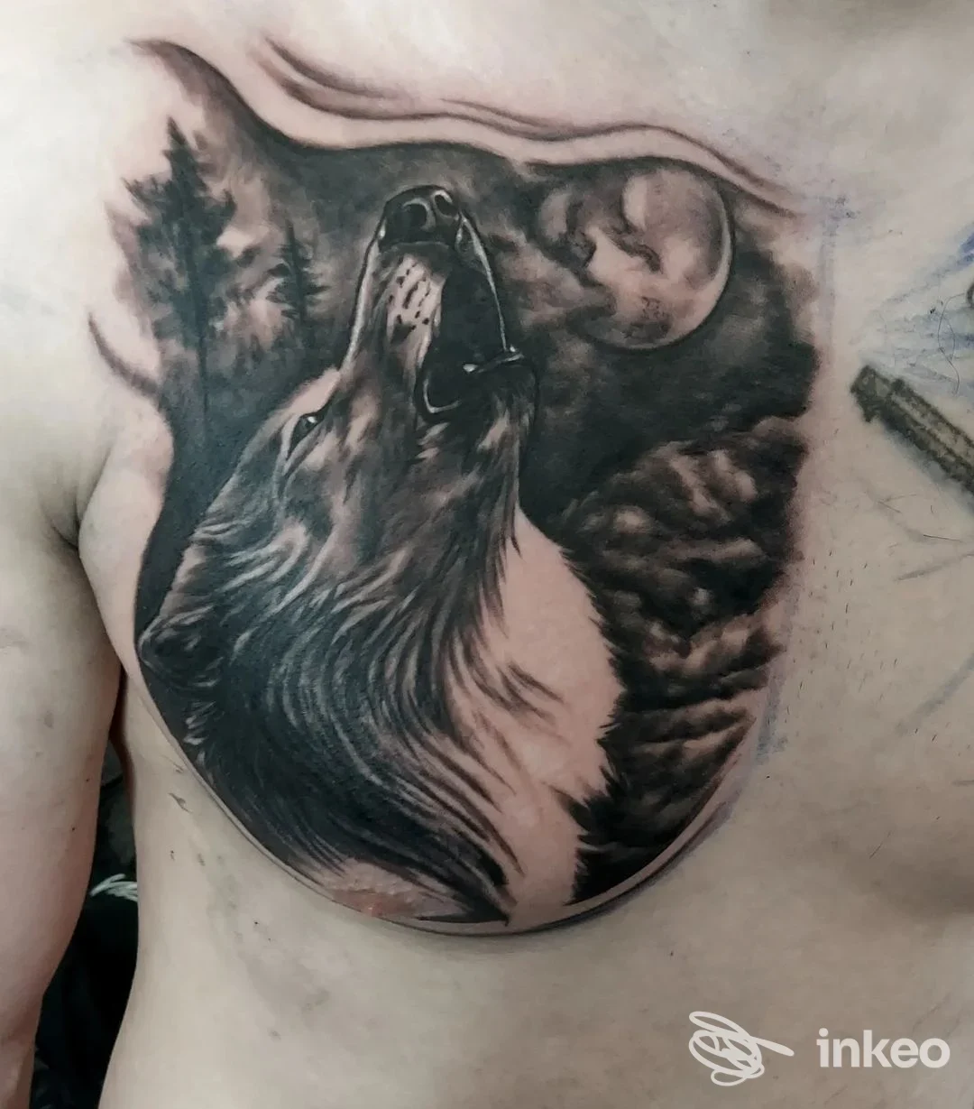 Tattoo realizzato sul torace raffigurante un lupo che ulula sotto una luna, eseguito sul corpo, con tonalità in bianco e nero; eseguito presso The Ink Man a Villa San Giovanni.