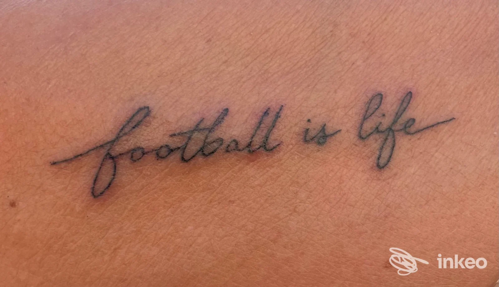 Tattoo visibile su pelle: scritta in stile script 'football is life' realizzata dal studio BELVETTOO a Pizzo.