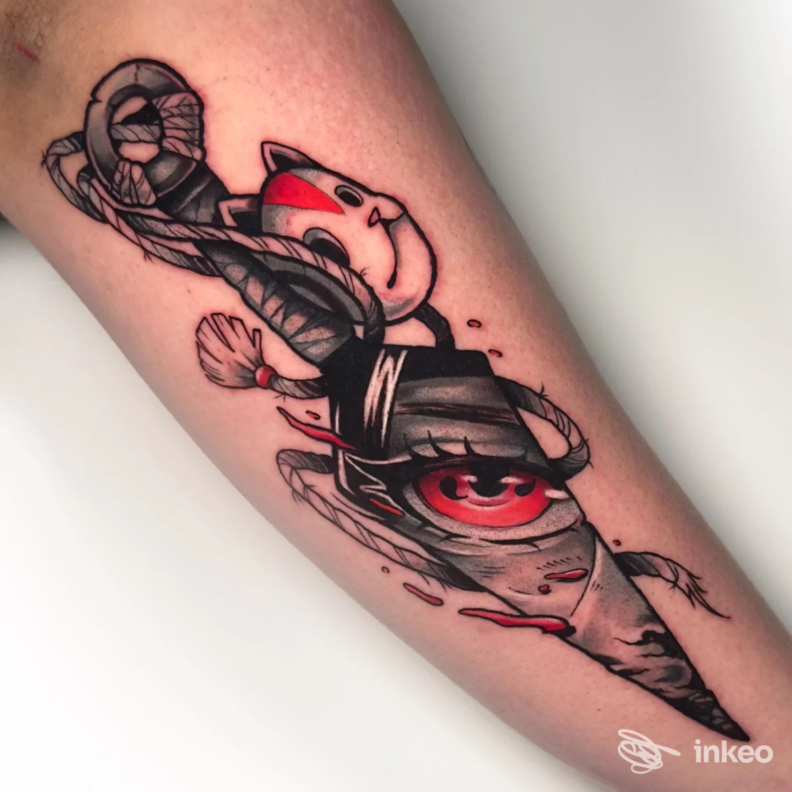 Tattoo su avambraccio raffigurante una figura stilizzata con colori nero e rosso, dettaglio pulito e colori pieni su pelle, stile grafico dinamico.