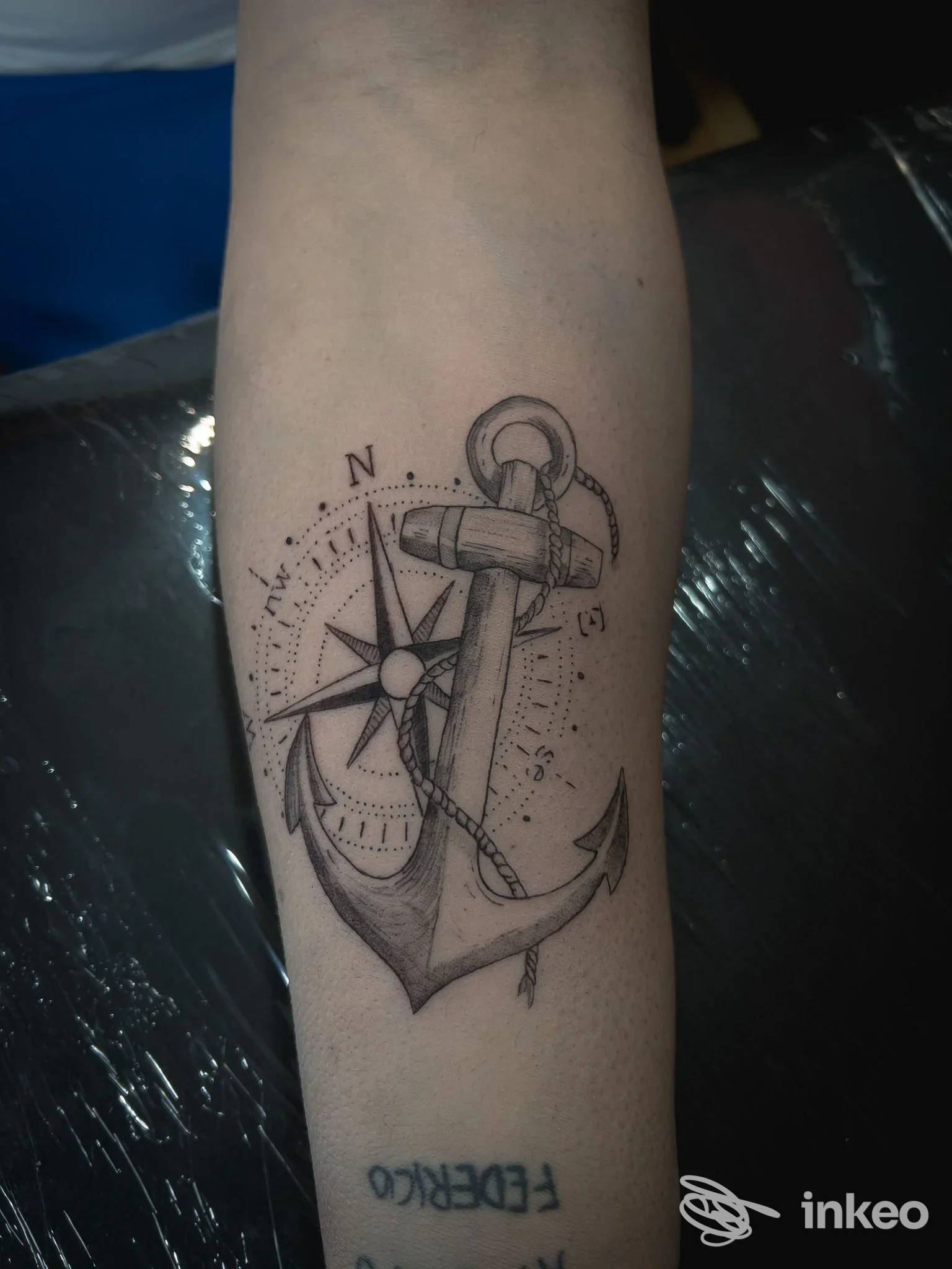 Tatuaggio reale su pelle: disegno con ancora e bussola su avambraccio, stile linework, eseguito presso Hollywood Tattoo, Reggio Calabria.