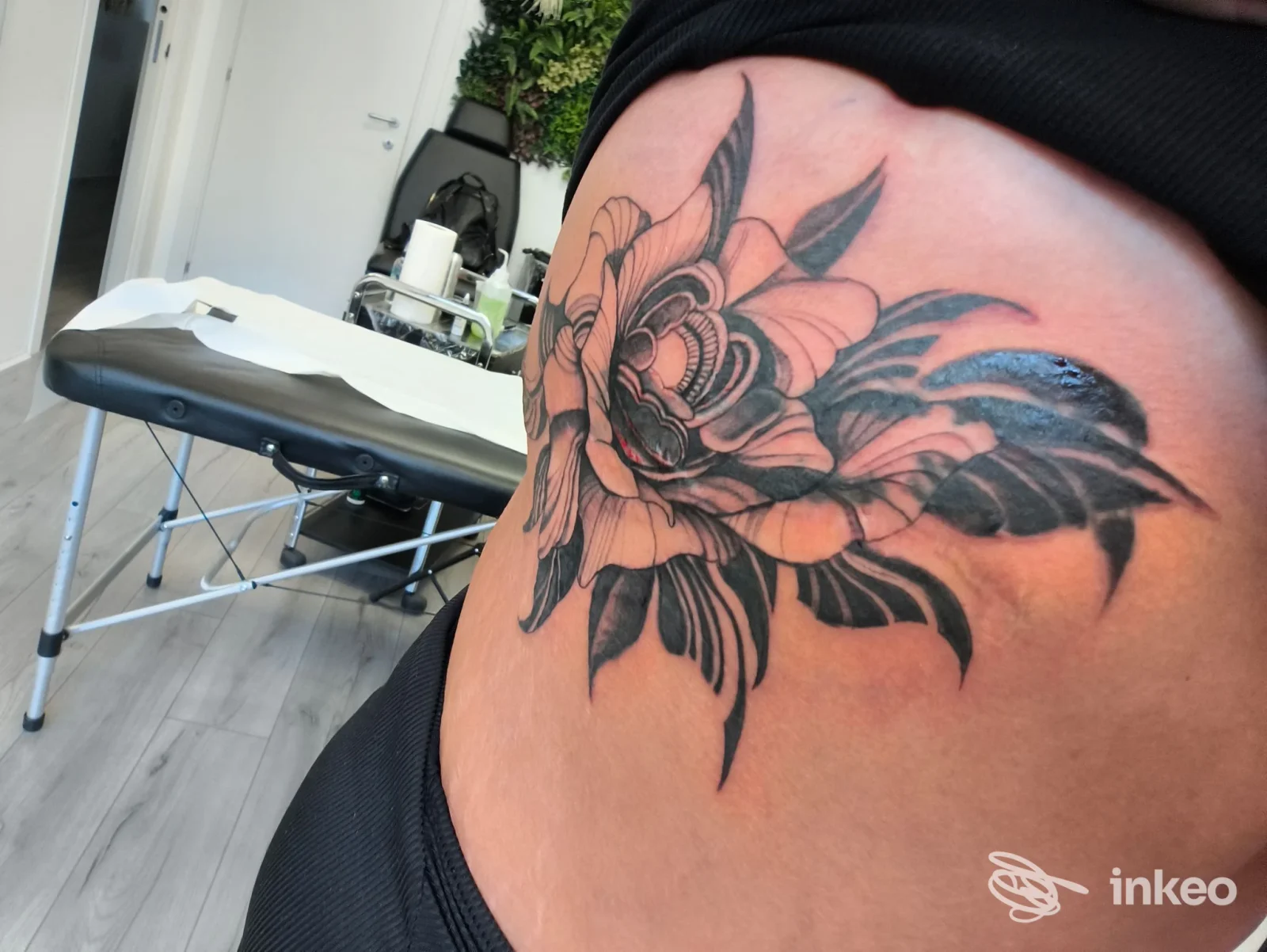 Tattoo floreale nero-grigio su pelle, visibile sull’anca/fianco di una persona, realizzato nello studio Pellerone a Reggio Calabria.