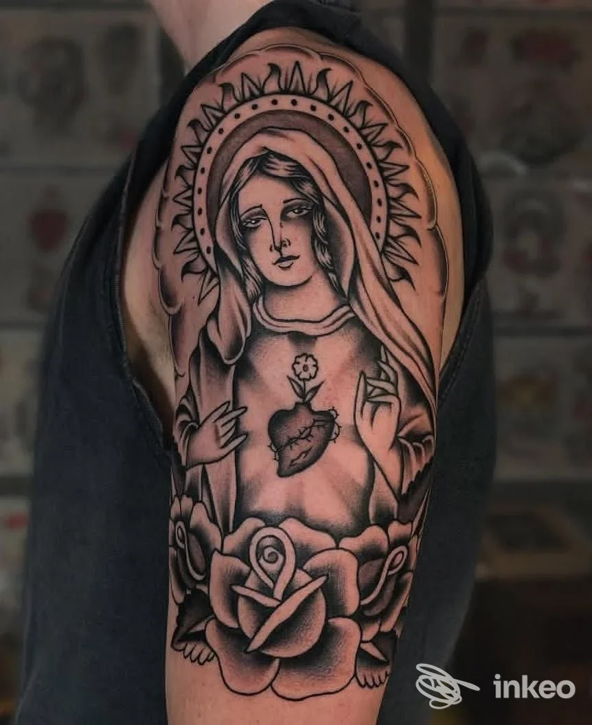 Tattoo sull'avambraccio raffigurante una Madonna con aureola, accompagnata da una rosa, in stile tradizionale bianco e nero.