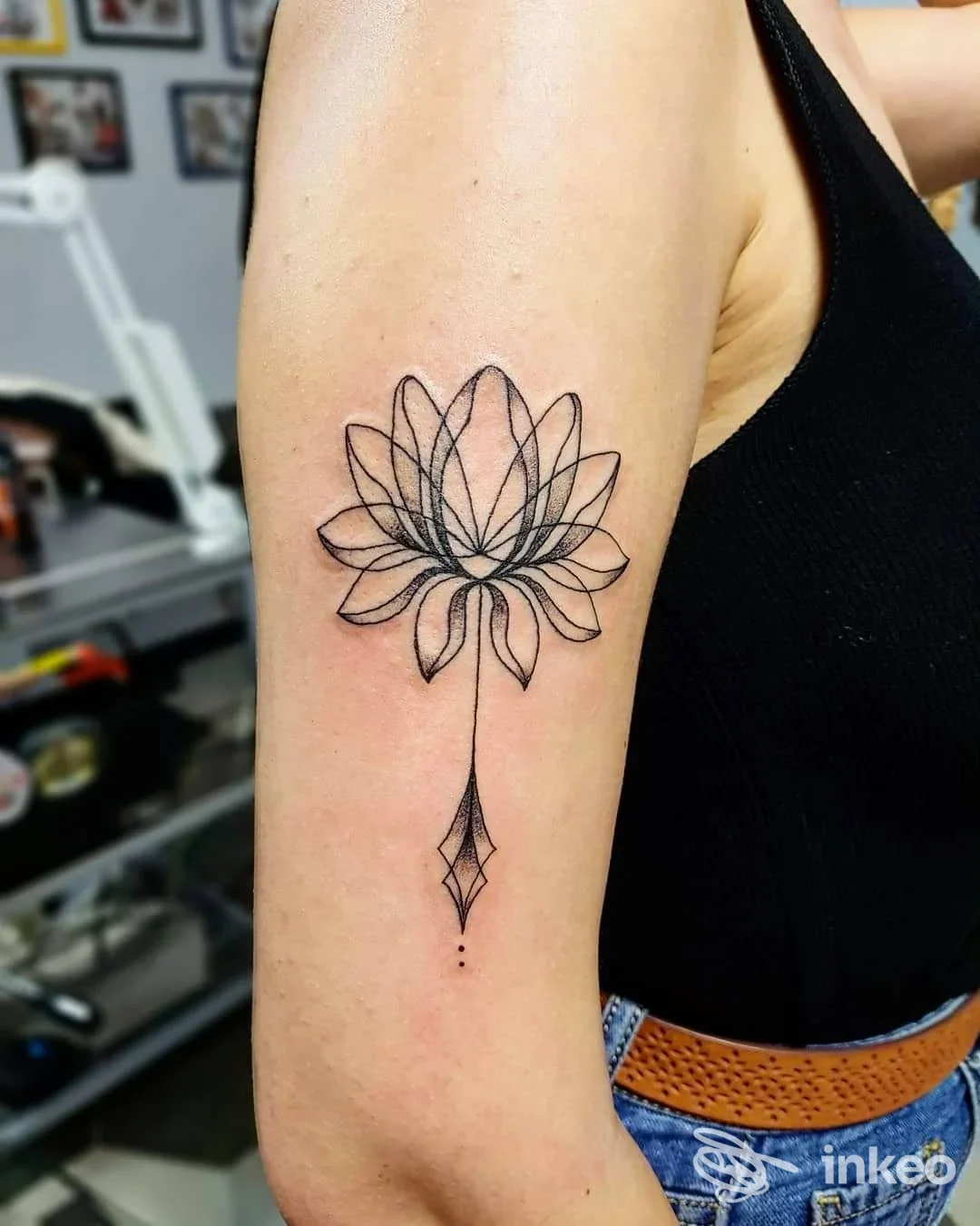Tatuaggio a rilievo sul braccio di una geometria di lotus, linea sottile e motivo a diamond, realizzato sulla pelle, senza elementi social o schermi visivi.