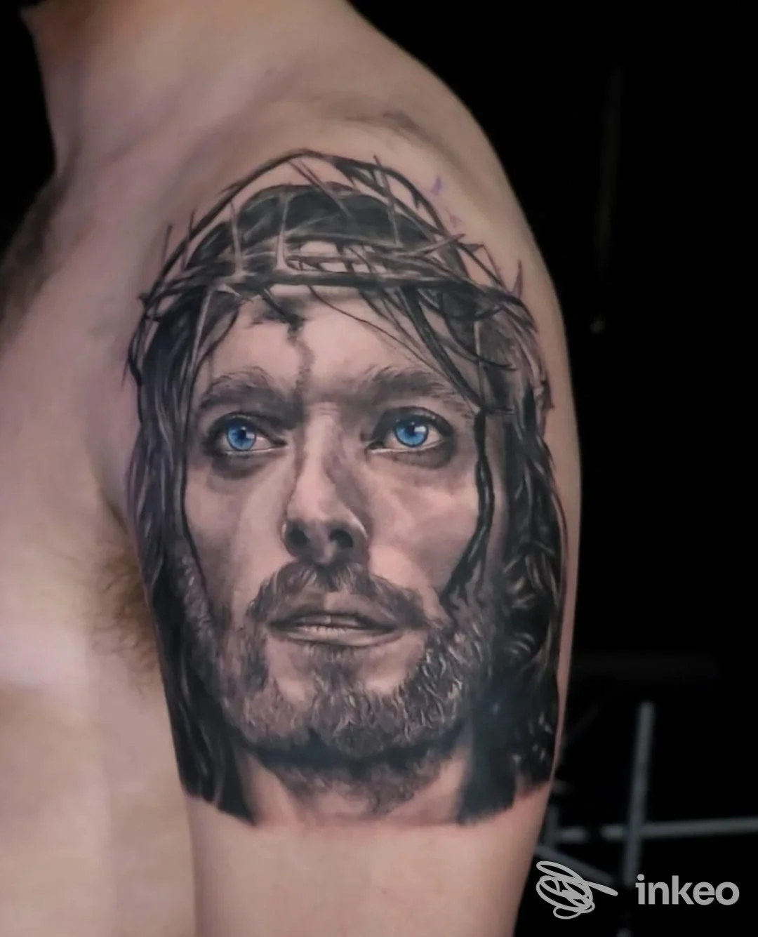 Tatuaggio realistico sul braccio raffigurante Gesù con corona di spine, realizzato da Fedel Tattoo a Crotone, privo di overlay o testo promozionale.