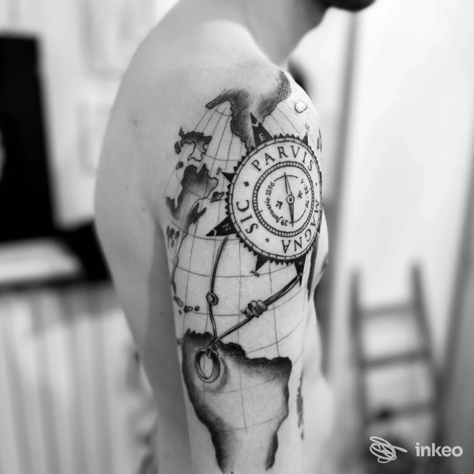 Tattoo visibile sulla pelle della spalla sinistra raffigurante una mappa del mondo e una bussola, in bianco e nero; eseguito su pelle reale, scatto in bianco e nero presso Watercolor's house.