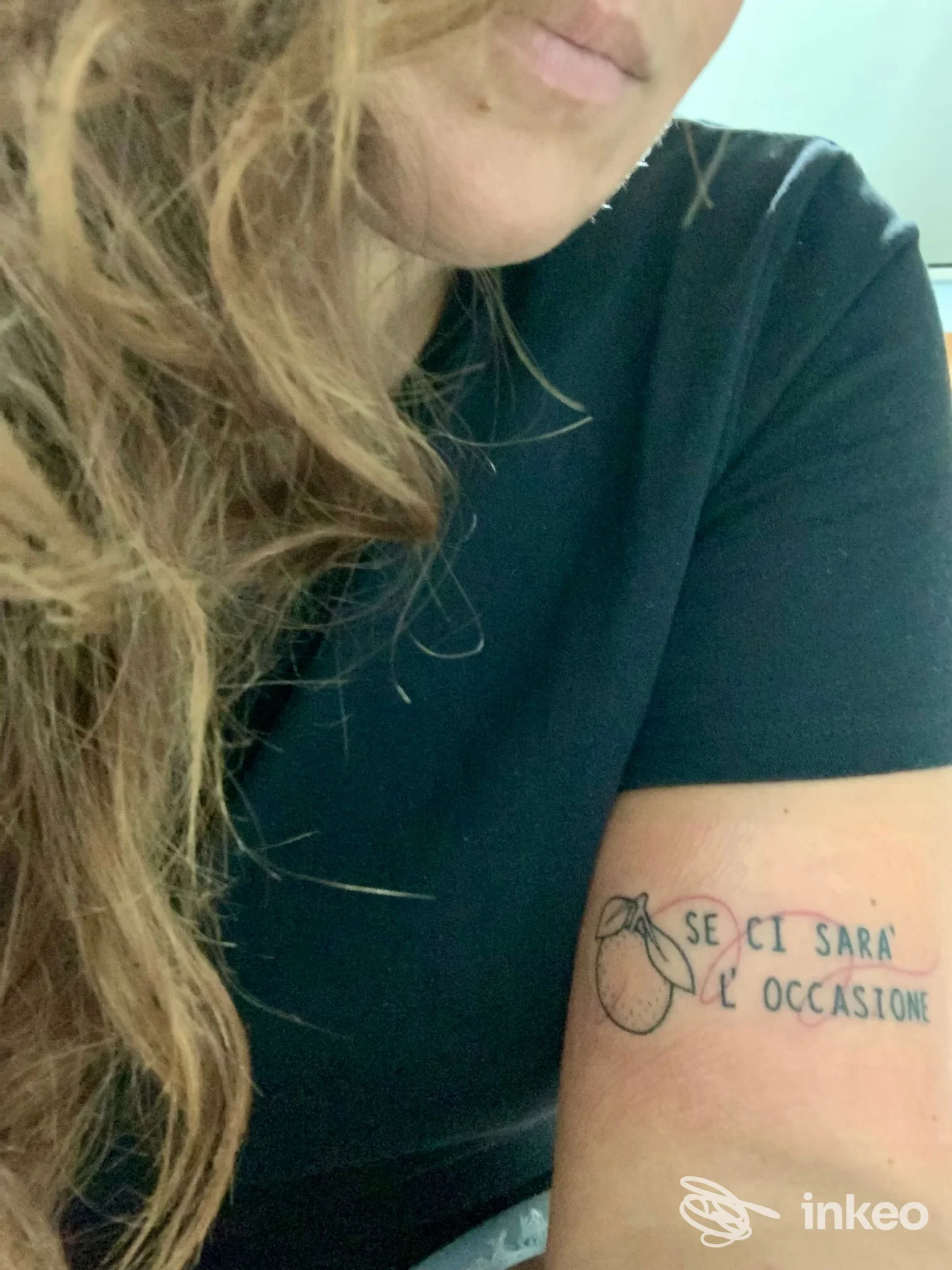 Tattoo visibile sul braccio sinistro: testo in italiano e un piccolo disegno; parte del corpo e della pelle sono visibili, non si vede volto completo.