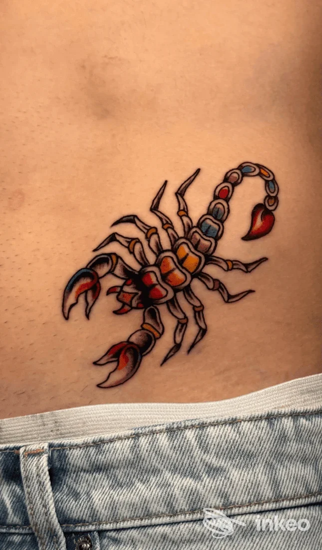 Tatuaggio colorato di uno scorpione sulla pelle, disegnato con contorni netti e colori vividi, visibile sull’addome/fianco.