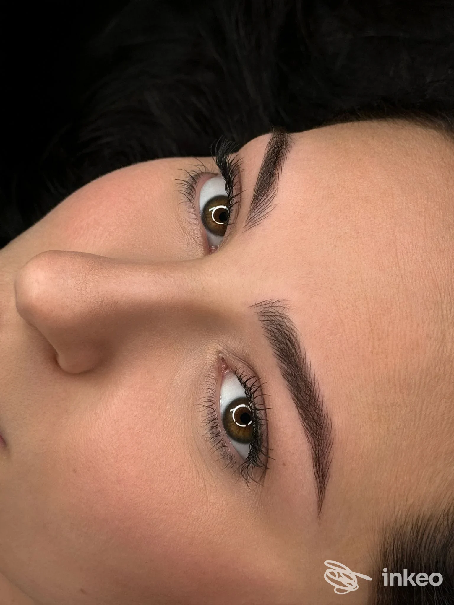 ritratto ravvicinato di una persona con sopracciglia definite, evidenti pigmentazioni di trucco permanente visibili sulle arcate sopracciliari, pelli naturali ben illuminate