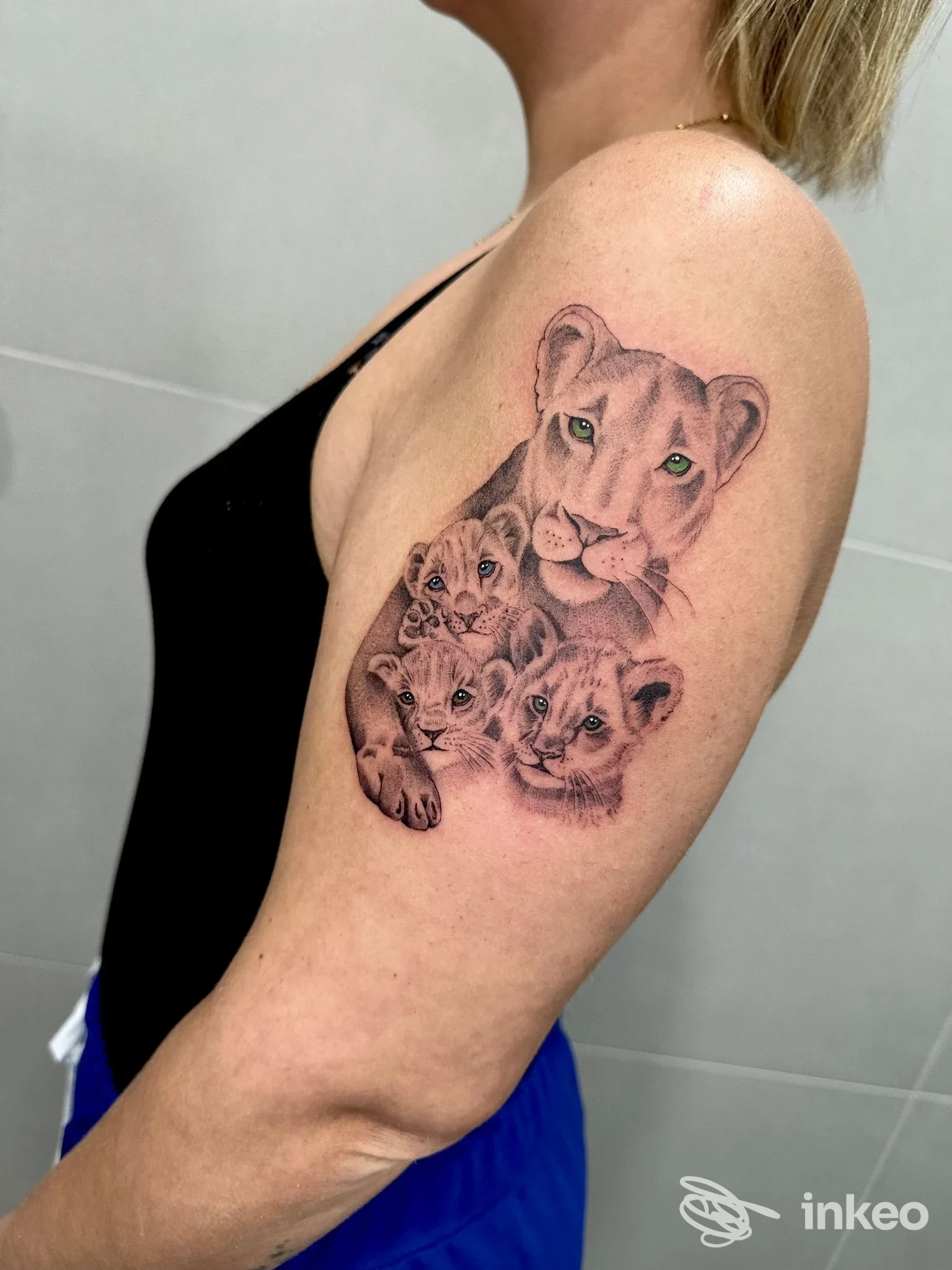 Tattoo raffigurante cuccioli di leone realizzati sulla parte esterna del braccio di una persona, colori reali e dettagli precisi.