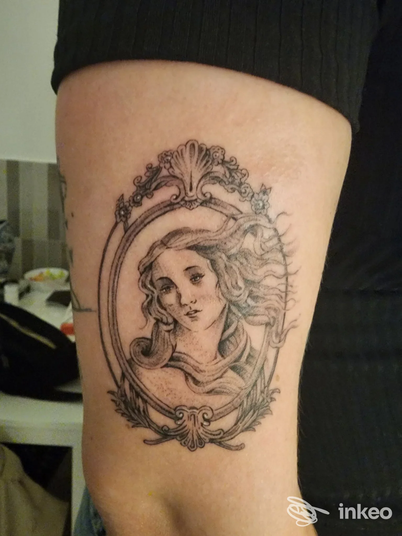 Tatuaggio sul braccio raffigurante un ritratto femminile dentro una cornice ornata, eseguito da BLACKINK TATTOO STUDIO a Napoli.