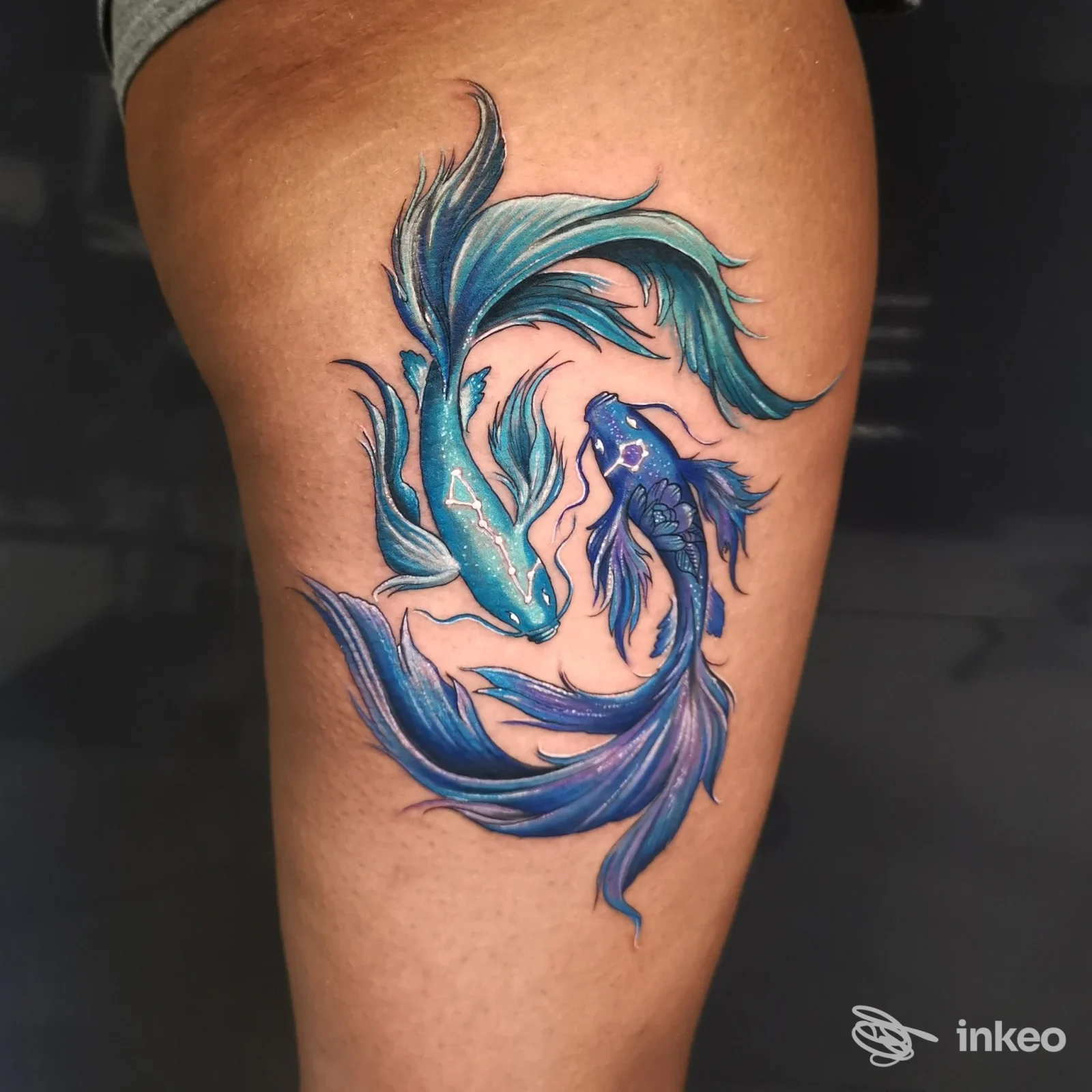 Tattoo realizzato su pelle della gamba raffigurante due carpe koi blu, eseguito dallo studio Buena Suerte Tattoo e Piercing Studio a Pozzuoli.