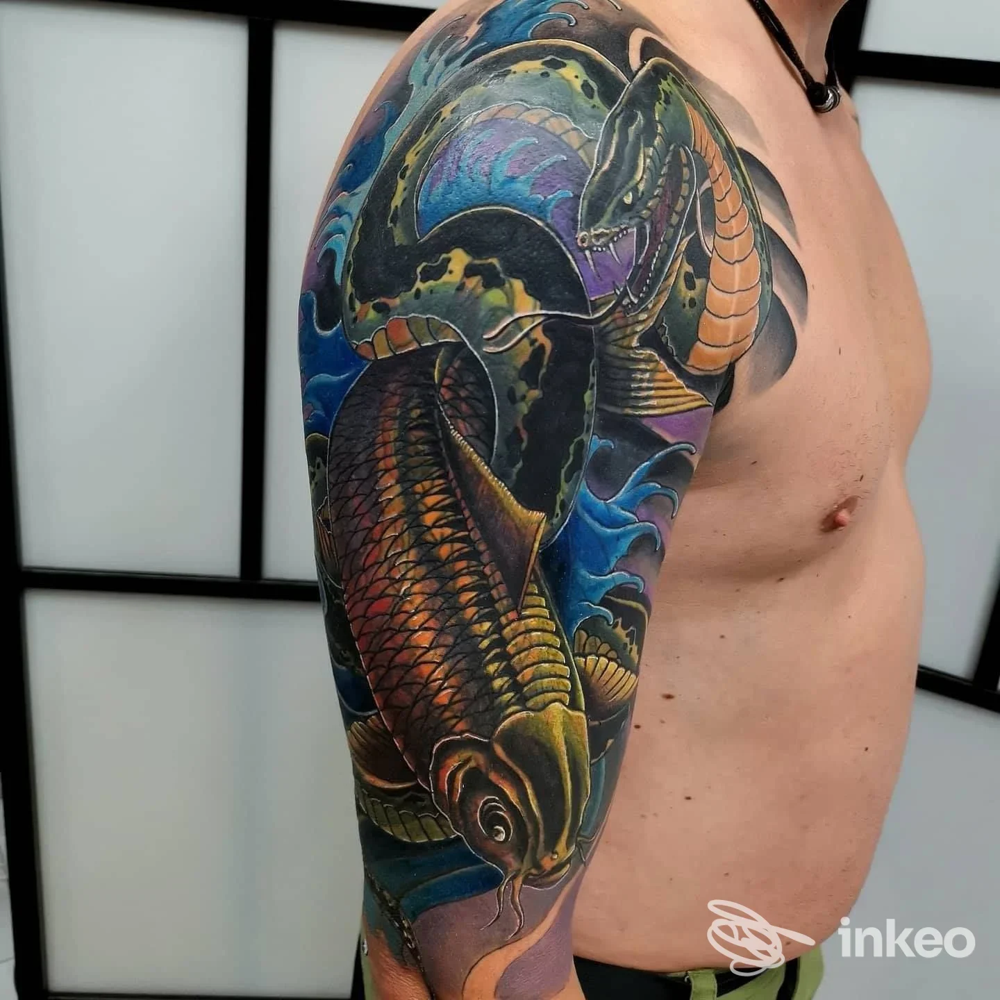 Tattoo colorato e dettagliato su braccio sinistro, con drago o creatura marina, dalla pelle nuda, visibile in primo piano, senza elementi d’interfaccia o testo sovrapposto.