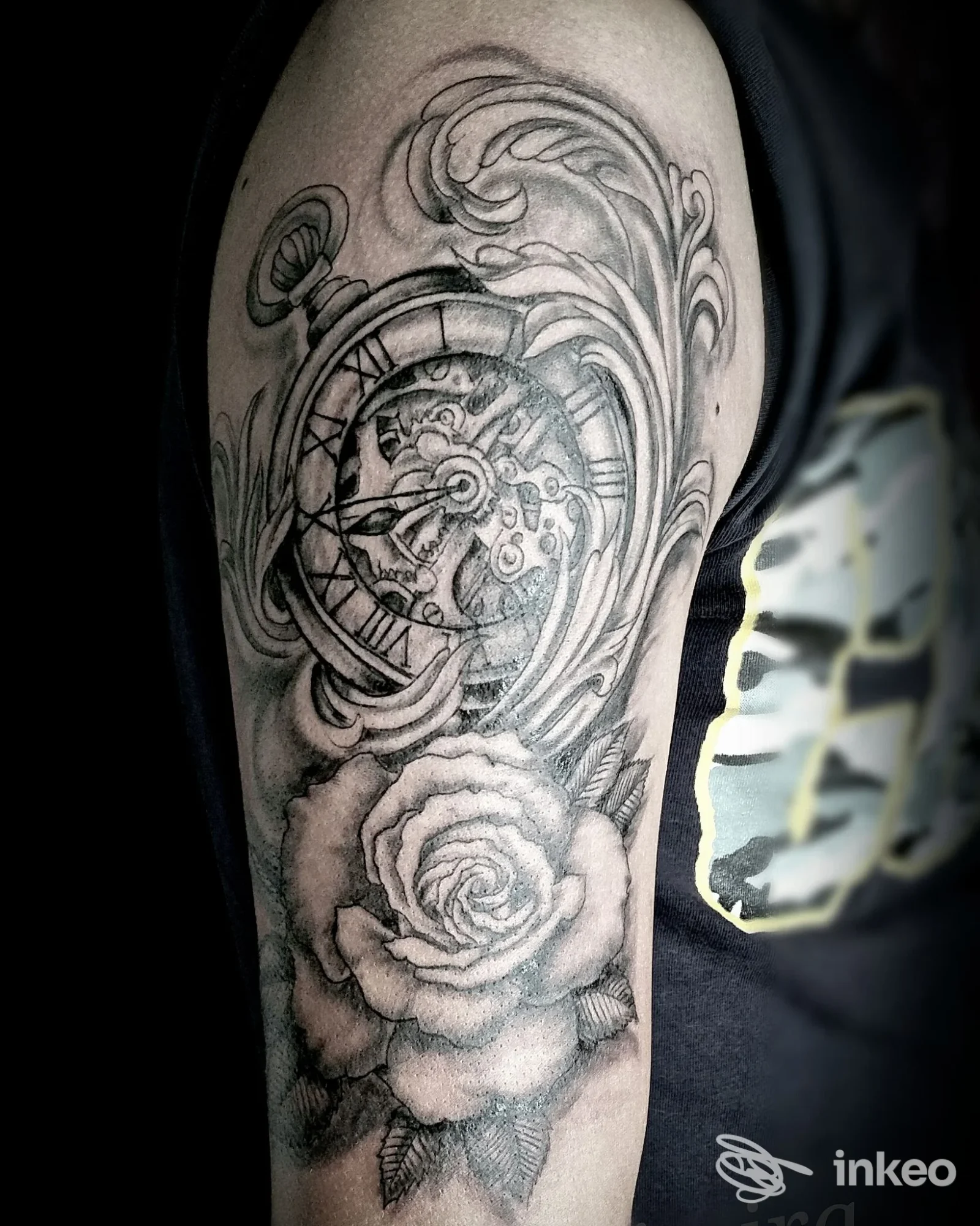Tattoo su braccio raffigurante un orologio da tasca con ingranaggi e una grande rosa, stile realismo in bianco e nero, lavoro corporeo visibile senza volto, studio Danimira a San Giorgio del Sannio.