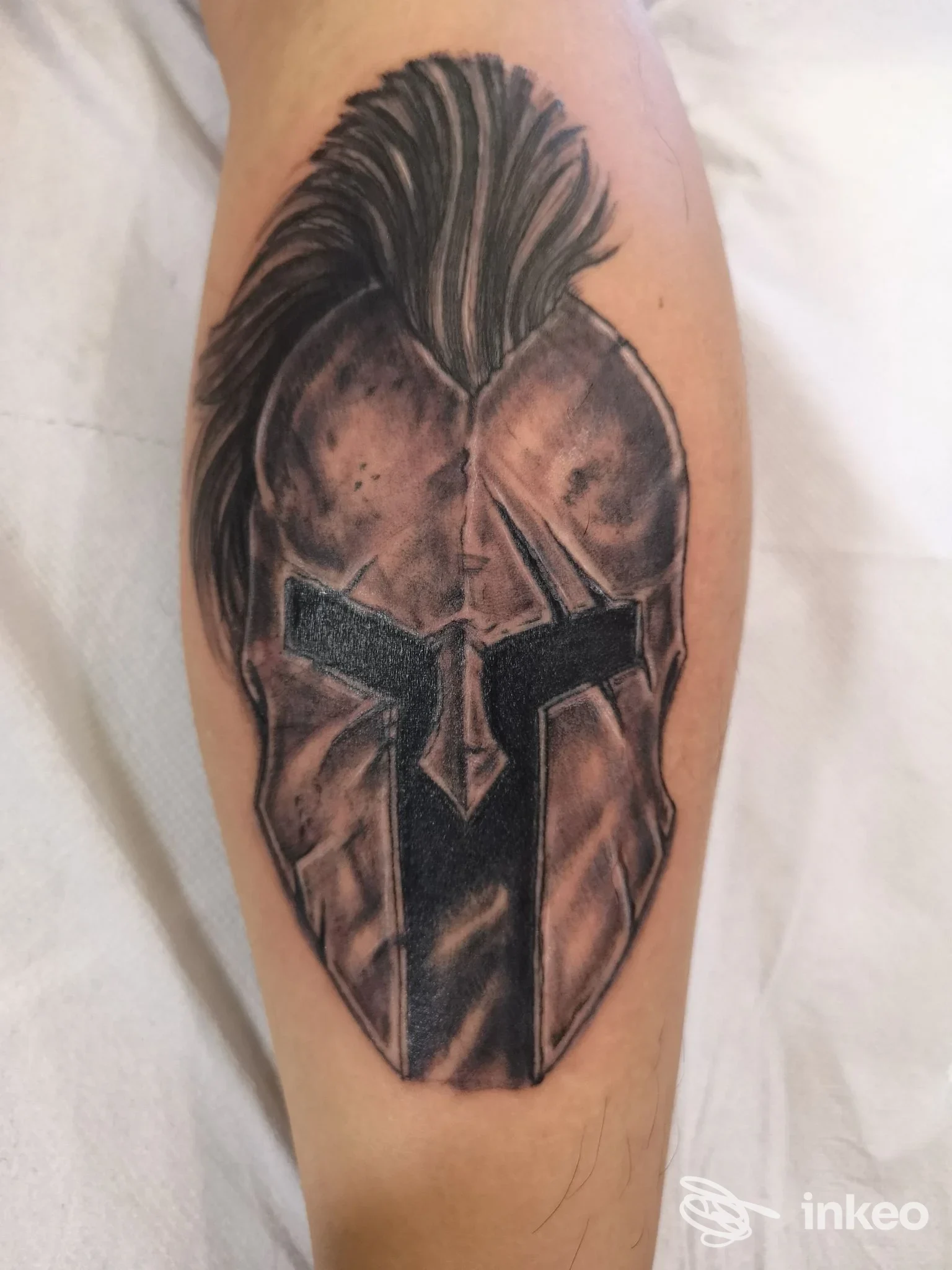 Tattoo sul braccio raffigurante un elmo greco scuro con criniera, realizzato da Tattoo & Art a Sant'Agnello.