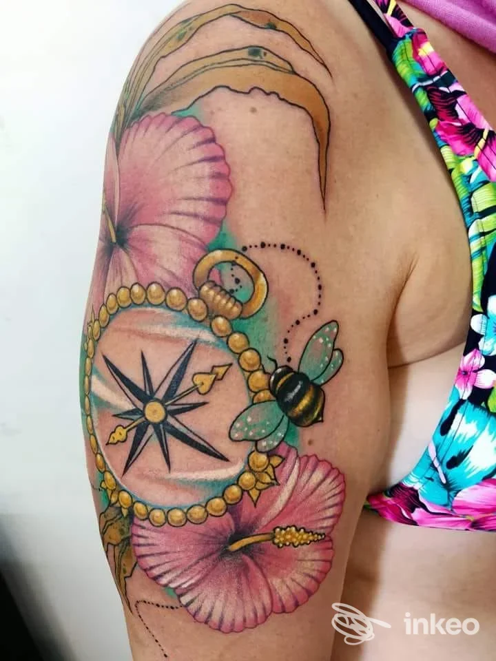 Tatuaggio visibile sull'avambraccio raffigurante un compasso circondato da perline e conchiglie, realizzato presso Old Art Tattoo Studio a Napoli.