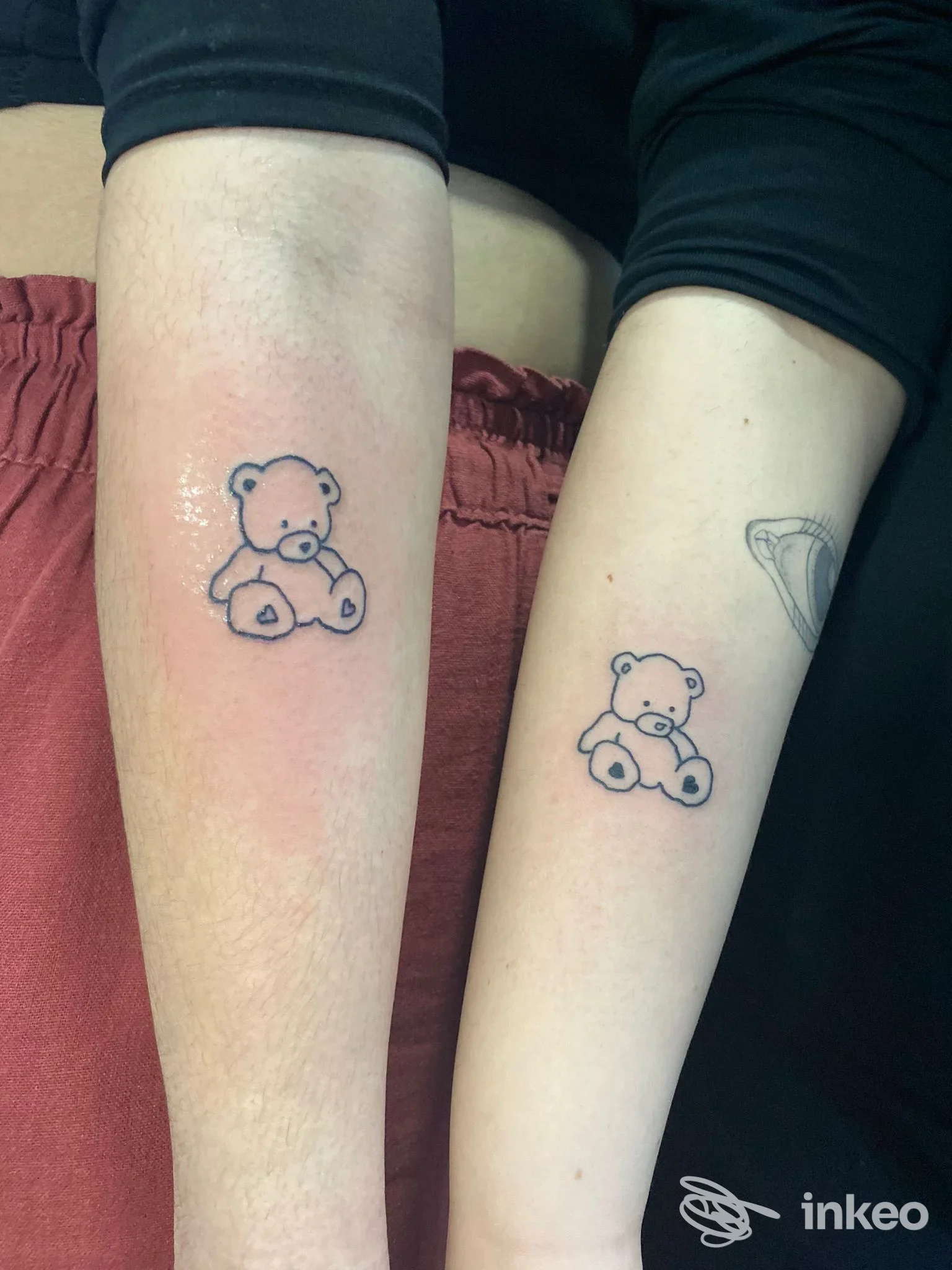 Due avambracci mostrano tatuaggi di orsetti su pelle, realizzati sulla cute, senza elementi di overlay o testo promozionale.