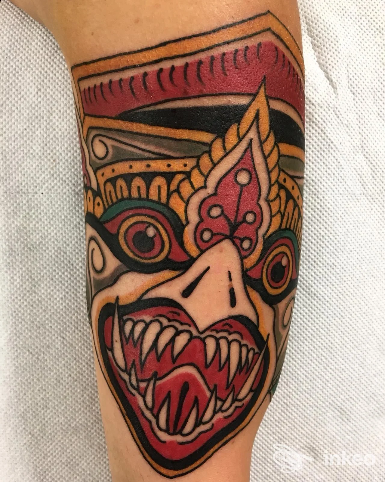 Tatuaggio colorato su avambraccio raffigurante una creatura stilizzata con denti aguzzi, realizzato su pelle. Studio Solid Rock Tattoo, Pozzuoli.