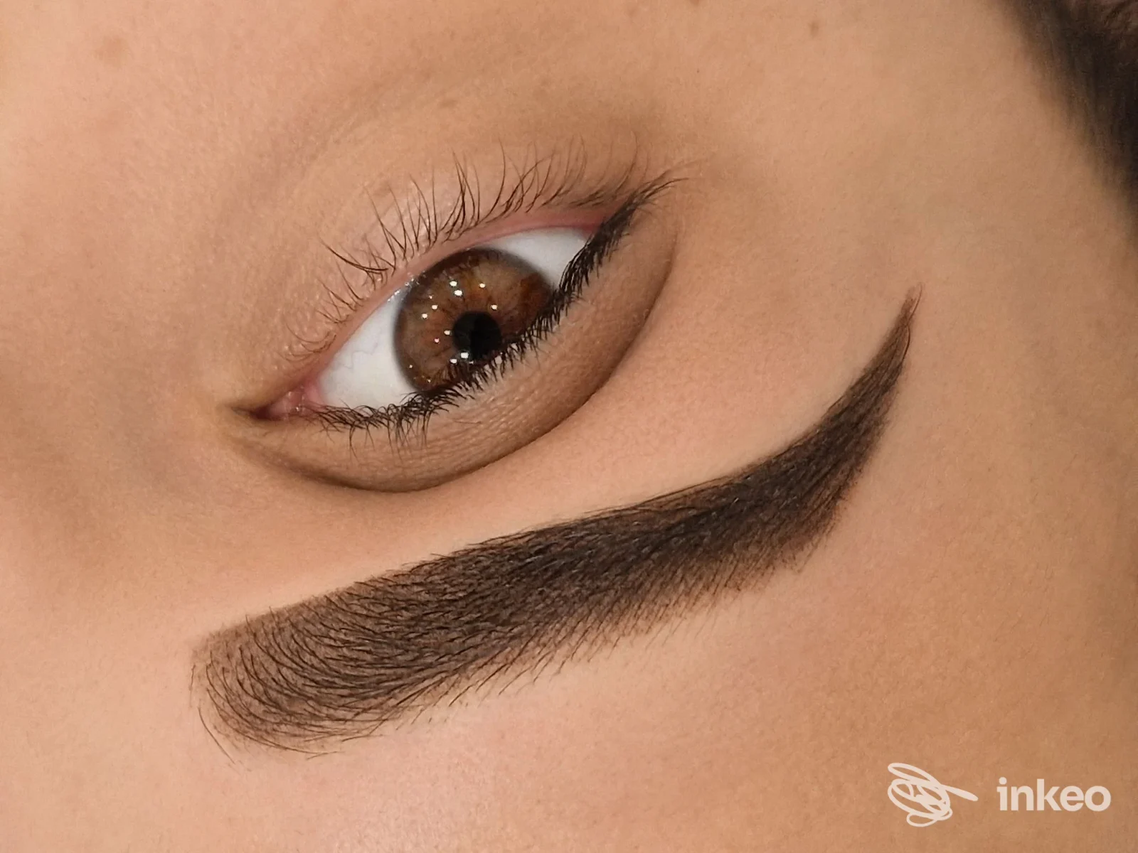 Trucco permanente dell’occhio: tratto di eyeliner tatuato visibile sulla pelle sotto l’occhio di una persona; contesto studio Alessandra Mazzella, Napoli.