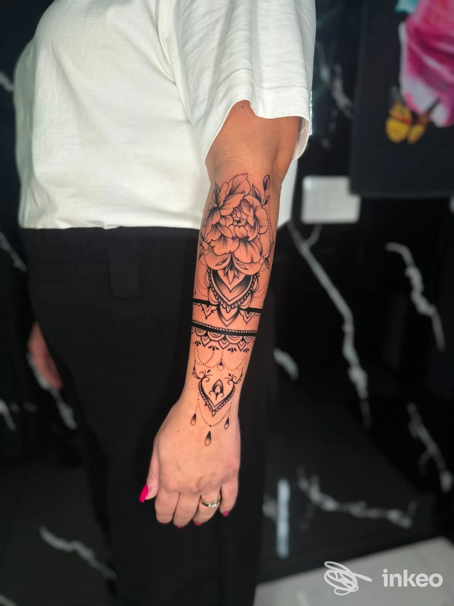 Braccio di una persona con un tatuaggio floreale dettagliato in linee nere sull’avambraccio, visibile senza viso. Studio Ernest Tattoo Ink, Napoli.