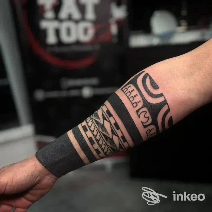 Avambraccio maschile con tatuaggio geometrico e bande nere, in primo piano, senza volto visibile; stile tribale/linee spesse, contrasto alto. Studio Morpiò Ink Tattoo, Giugliano in Campania.