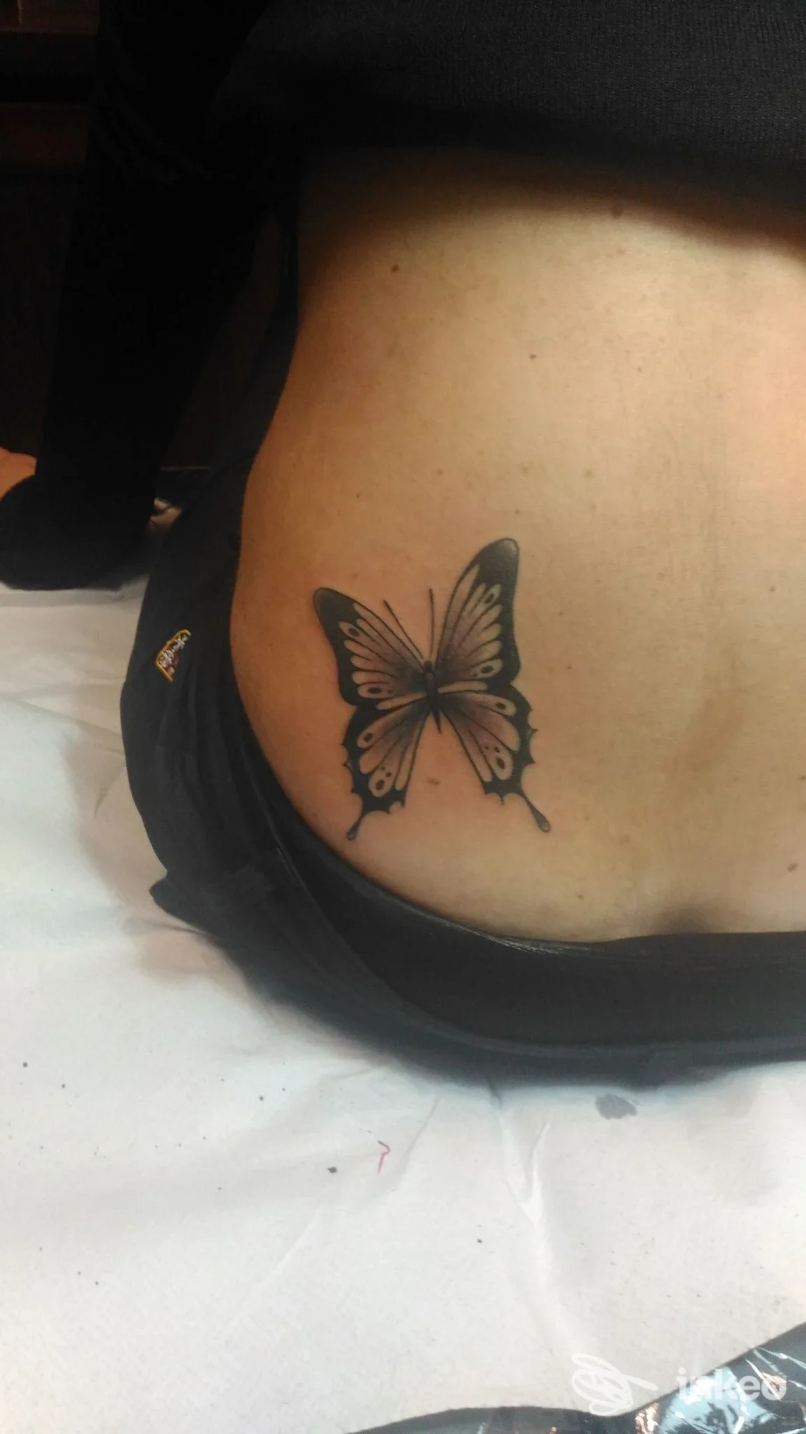 Tatuaggio reale sul fianco sinistro: farfalla nera stilizzata su pelle, realizzato dallo studio Costattoo a Marigliano.