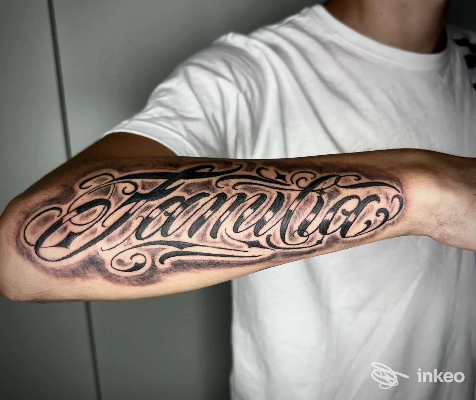 Tatuaggio elaborato sull'avambraccio, lettering curvilineo ben definito visibile in studio a Salerno, realizzato da Studio Elena Puffo Brontolone.