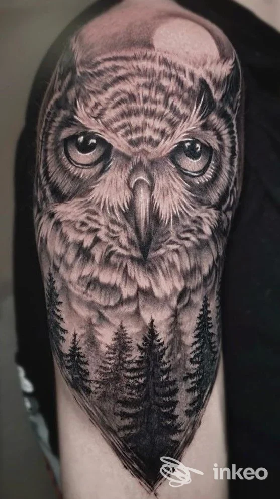 Tattoo realistico di gufo con foresta sul braccio, realizzato da Non Solo Tattoo a Caserta, in tonalità nere e grigie.