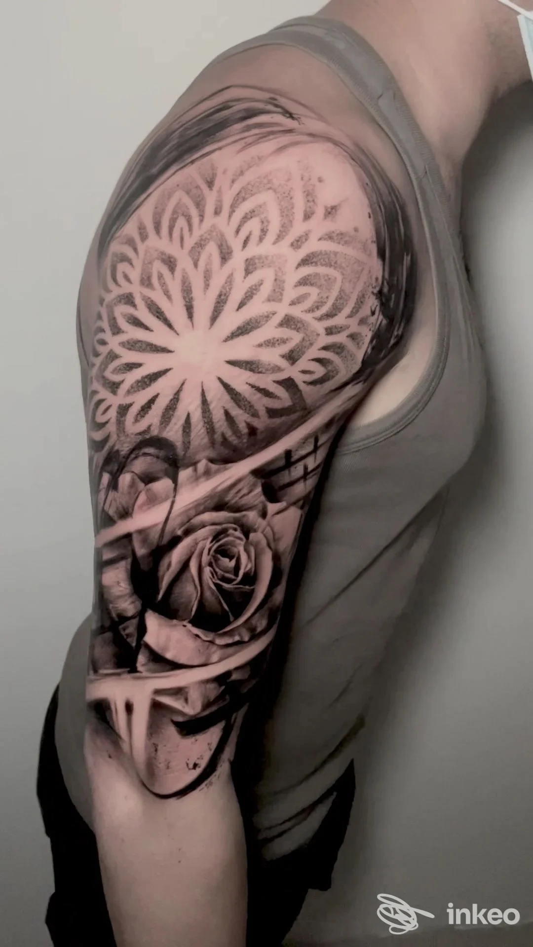 Tatuaggio realistico sull’avambraccio/inguine della spalla: motivo floreale circolare tipo mandala sovrapposto a una rosa, realizzato sulla pelle, senza volto visibile, in studio a Salerno, Luig Gala Tattoo.