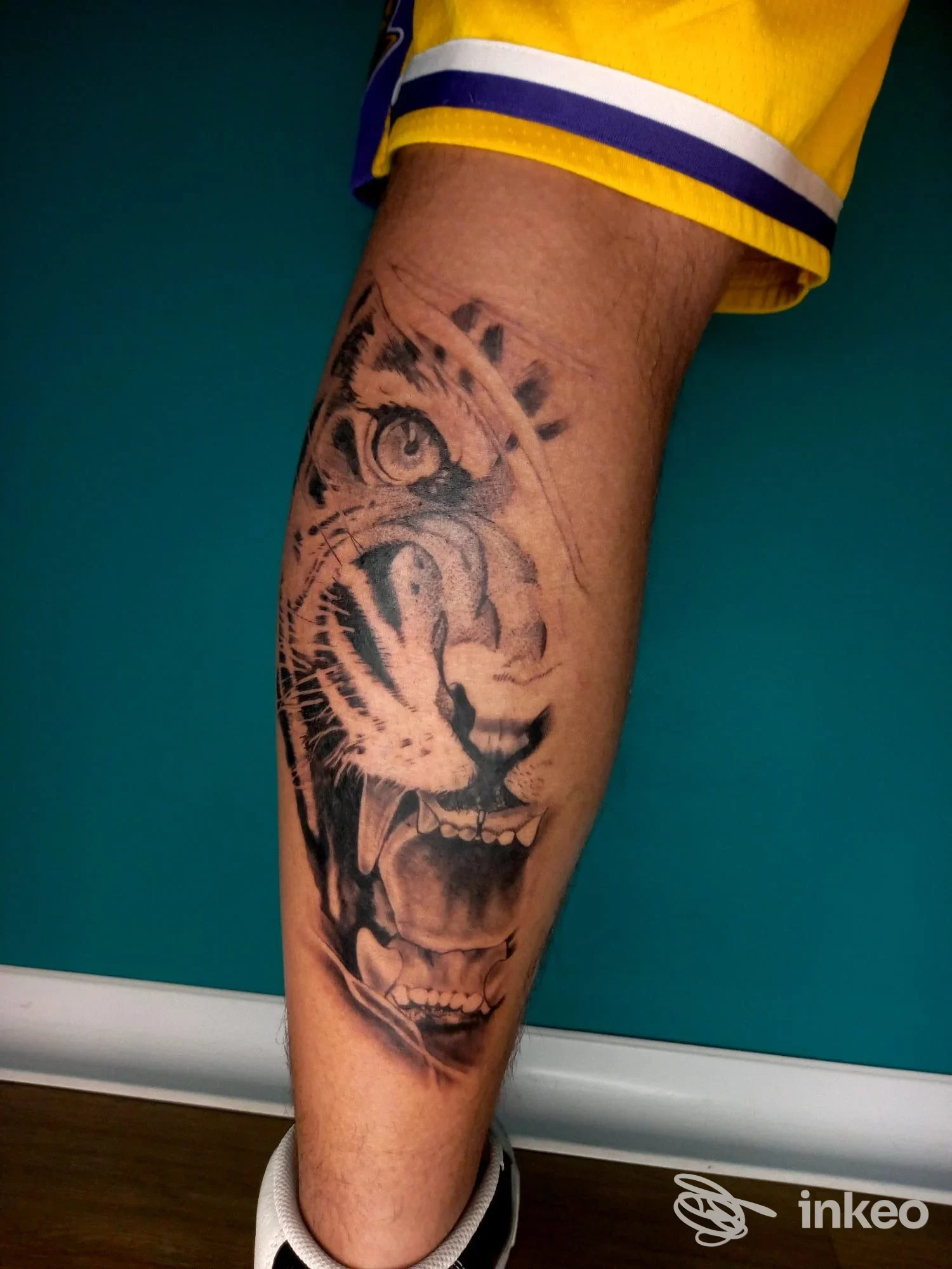 Tattoo tiger realistico visibile su gamba, realizzato sul soggetto, senza overlay sociale o immagine di uno schermo; tecnica e inchiostro evidenti.