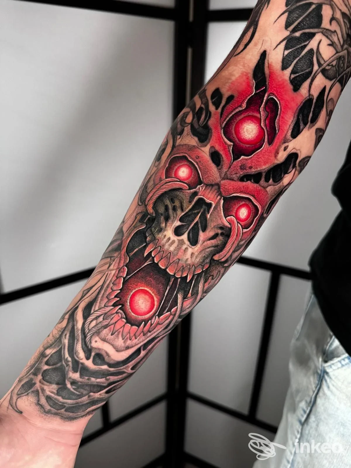 Tattoo sul braccio realizzato presso Tattoo Club di Napoli: teschi rossi su sfondo scuro, design realistico e dettagliato.