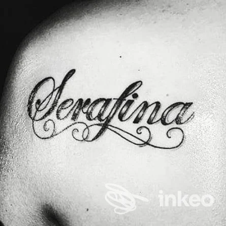 Tattoo in stile calligrafico su pelle: la parola 'Serafina' incisa con ornamenti cursivi. Studio Serafina’s Ink, Eboli.