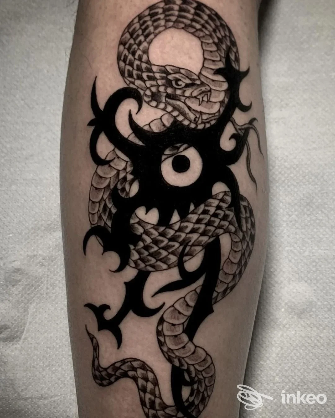 Tattoo su pelle raffigurante serpente e elementi tribali neri, eseguito nello studio Enzo Brandi a Napoli.