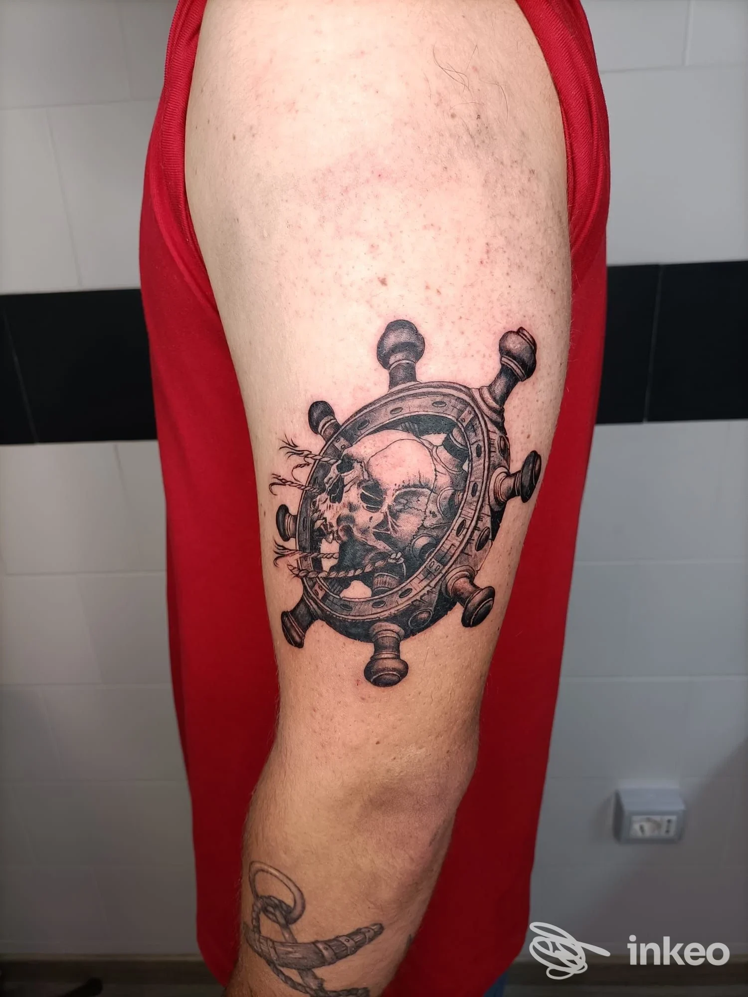 Tattoo su braccio raffigurante timone con teschio in stile realistico, eseguito da INKiostro tattoo art a Mugnano del Cardinale.