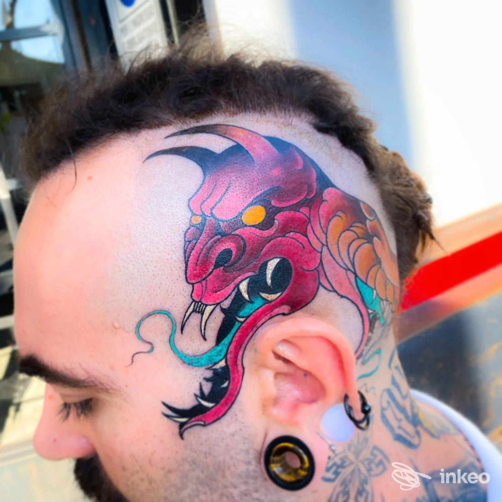 Tatuaggio a tema drago colorato sulla testa, lato tempia e parte del cranio di una persona, tatuaggio corporeo ben visibile, nessun effetto di overlays o testo straniero.