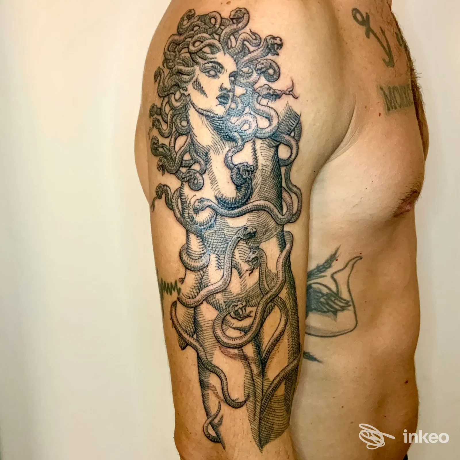 Tatuaggio sul braccio sinistro con figura mitologica realizzato sulla pelle, scuro e dettagliato.