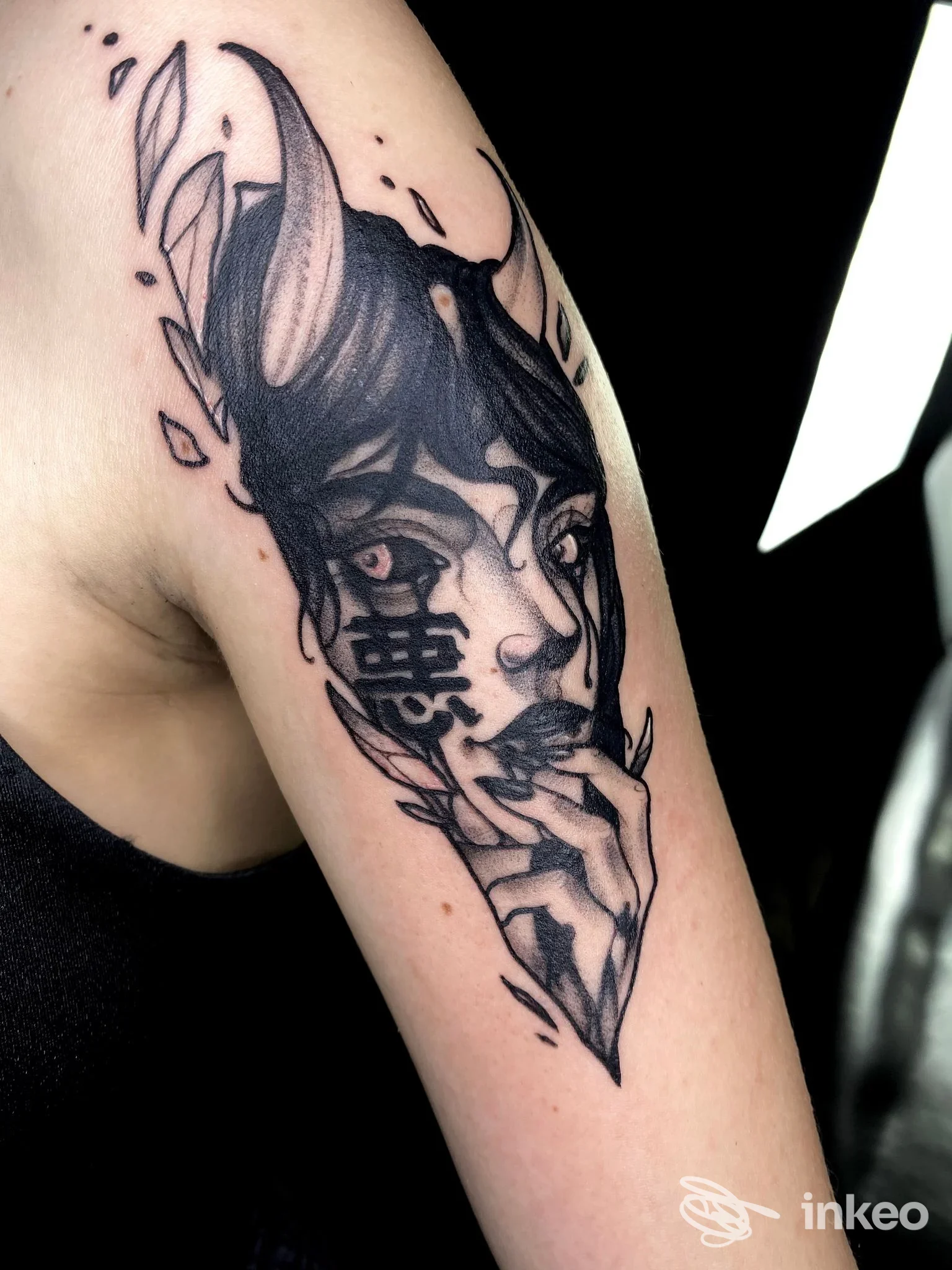 Tattoo su braccio raffigurante una testa animale stilizzata con linee nere e sfumature, visibile su pelle chiara senza volto umano intero.