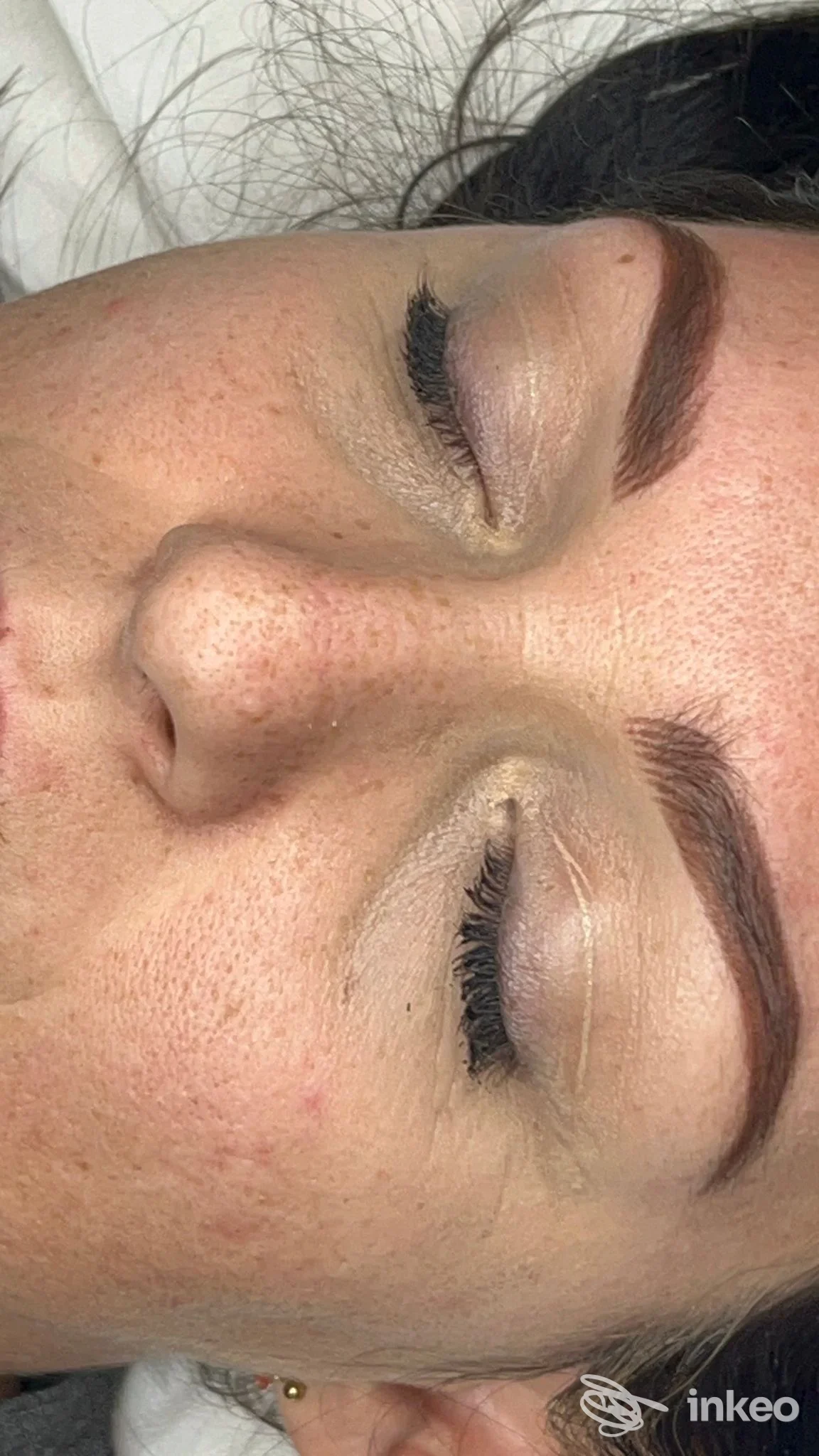 Sopracciglia rifinite e marcate con trucco permanente su pelle, viso parzialmente visibile con occhi chiusi, primo piano sugli occhi e sopracciglia, studio Conci permanent make up ad Aversa.