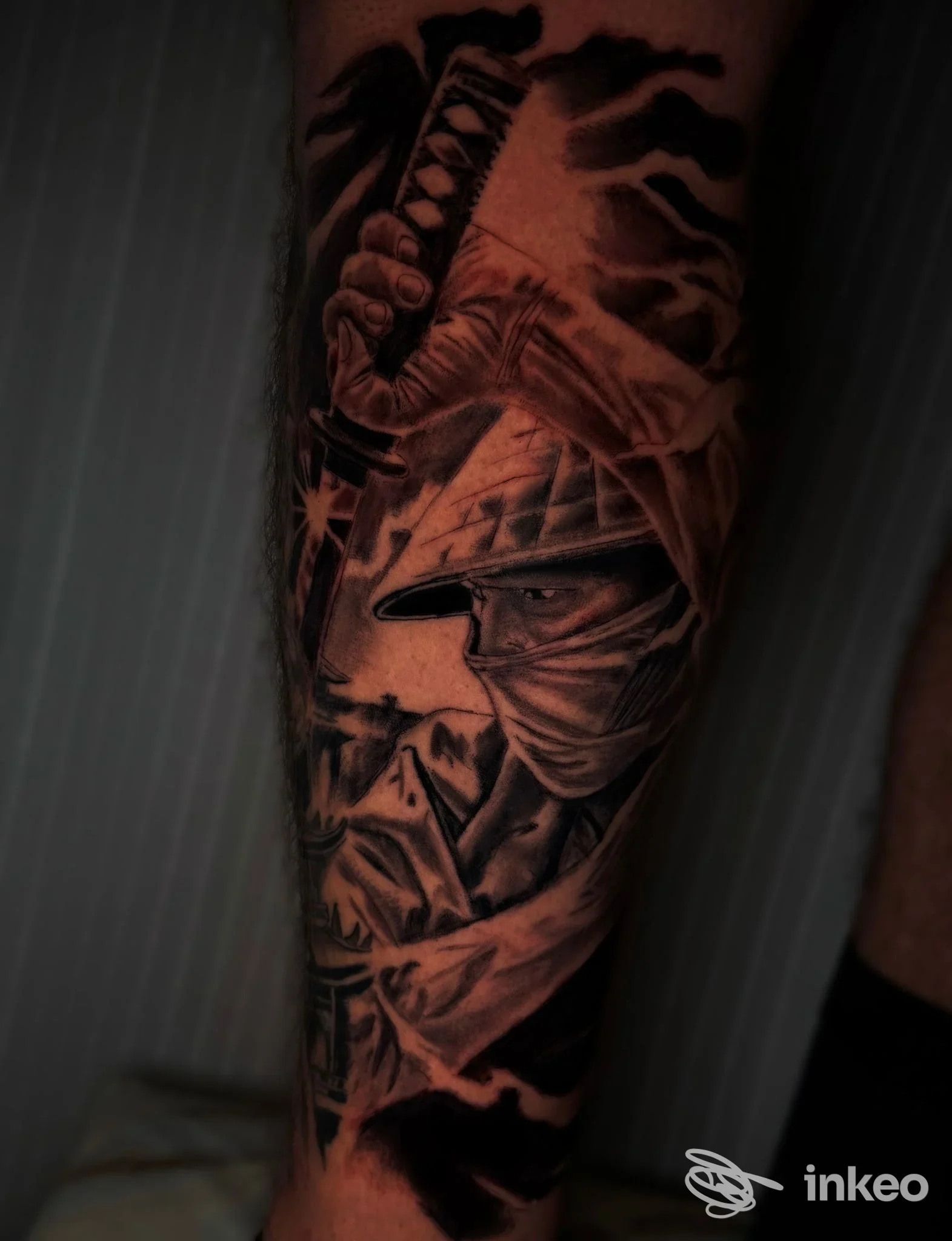 Tatuaggio realistico in bianco e nero su polpaccio, dettagli di lama e figure in ombra, eseguito dal/vittorio Sarpa Tattoo a Napoli, visibile su pelle reale.