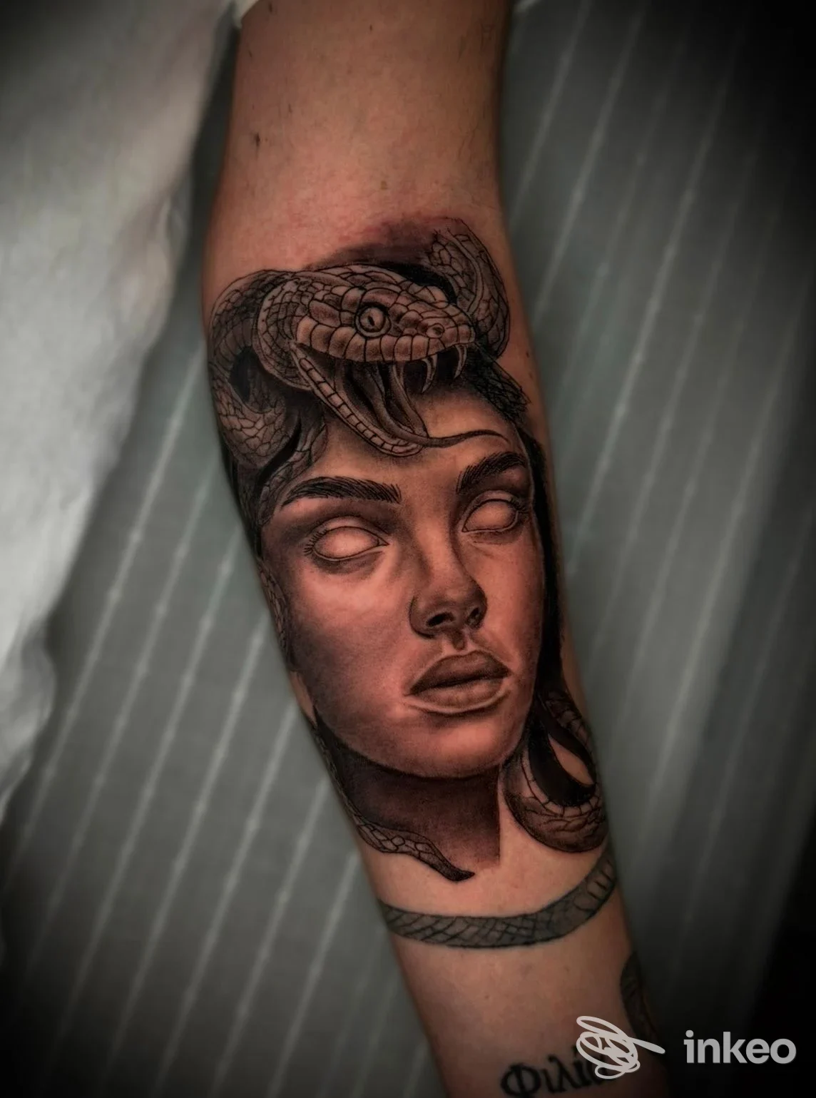 Tattoo realistico su avambraccio: ritratto femminile con serpente avvolto, eseguito sulla pelle nel studio Vittorio Sarpa Tattoo a Napoli.