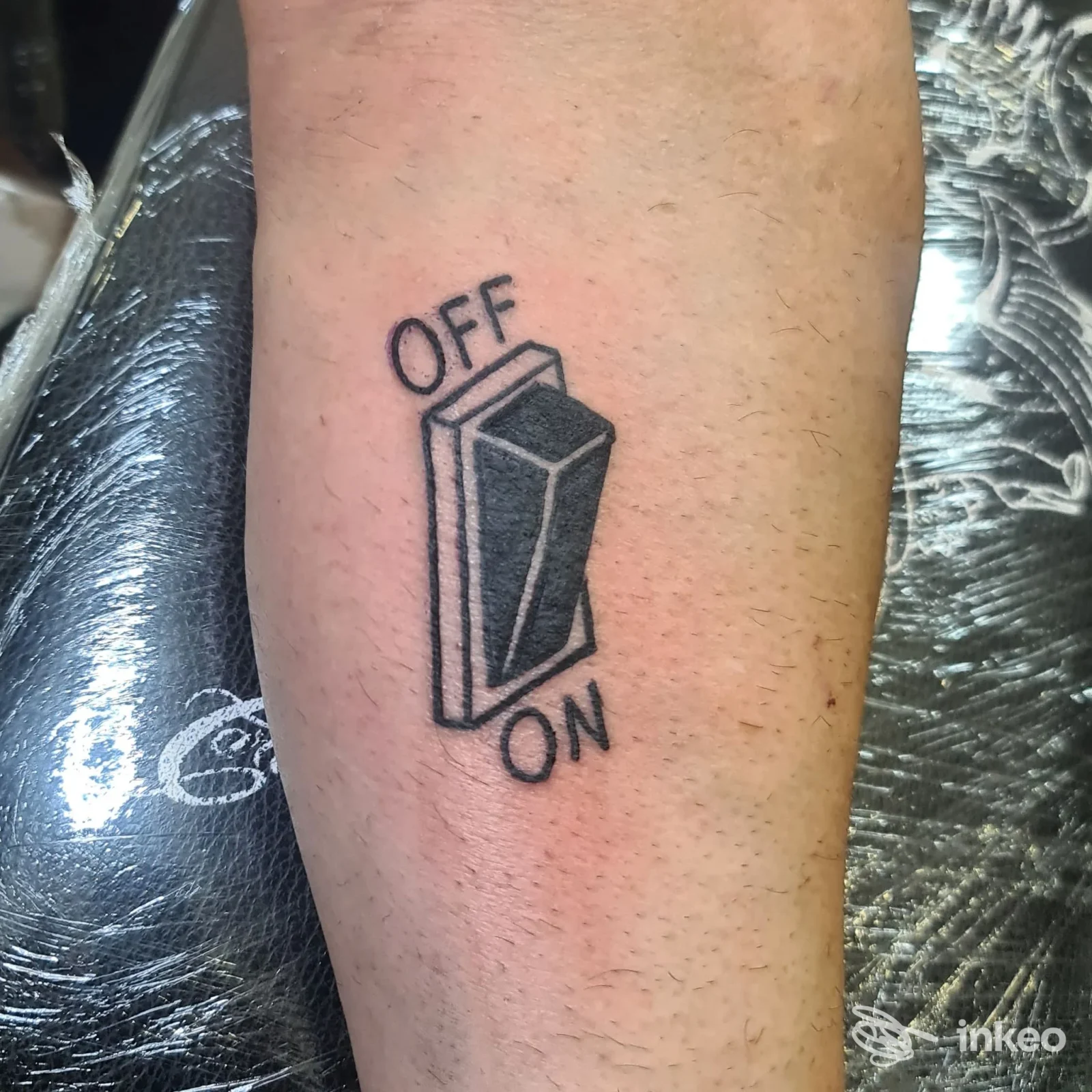 Tattoo su pelle raffigurante un interruttore ON/OFF in stile line art, eseguito su avambraccio; firma visibile con contesto di studio Straight to Hell Tattoo Club, Caserta.