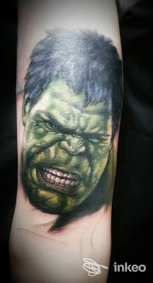 Tattoo realistico sul braccio raffigurante Hulk, colori verdi e neri, dettaglio accurato e ombreggiato.