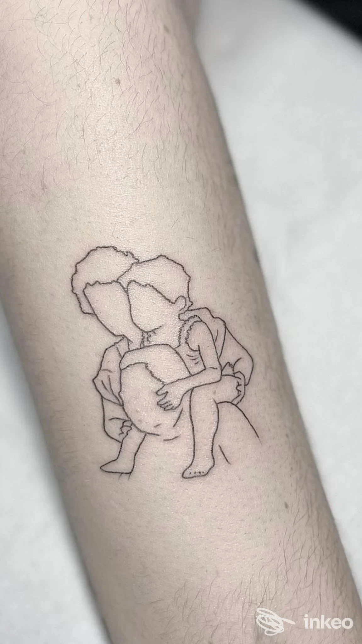 Tattoo lineare di due persone che si abbracciano sull'avambraccio, contorno sottile, disegno su pelle chiara.