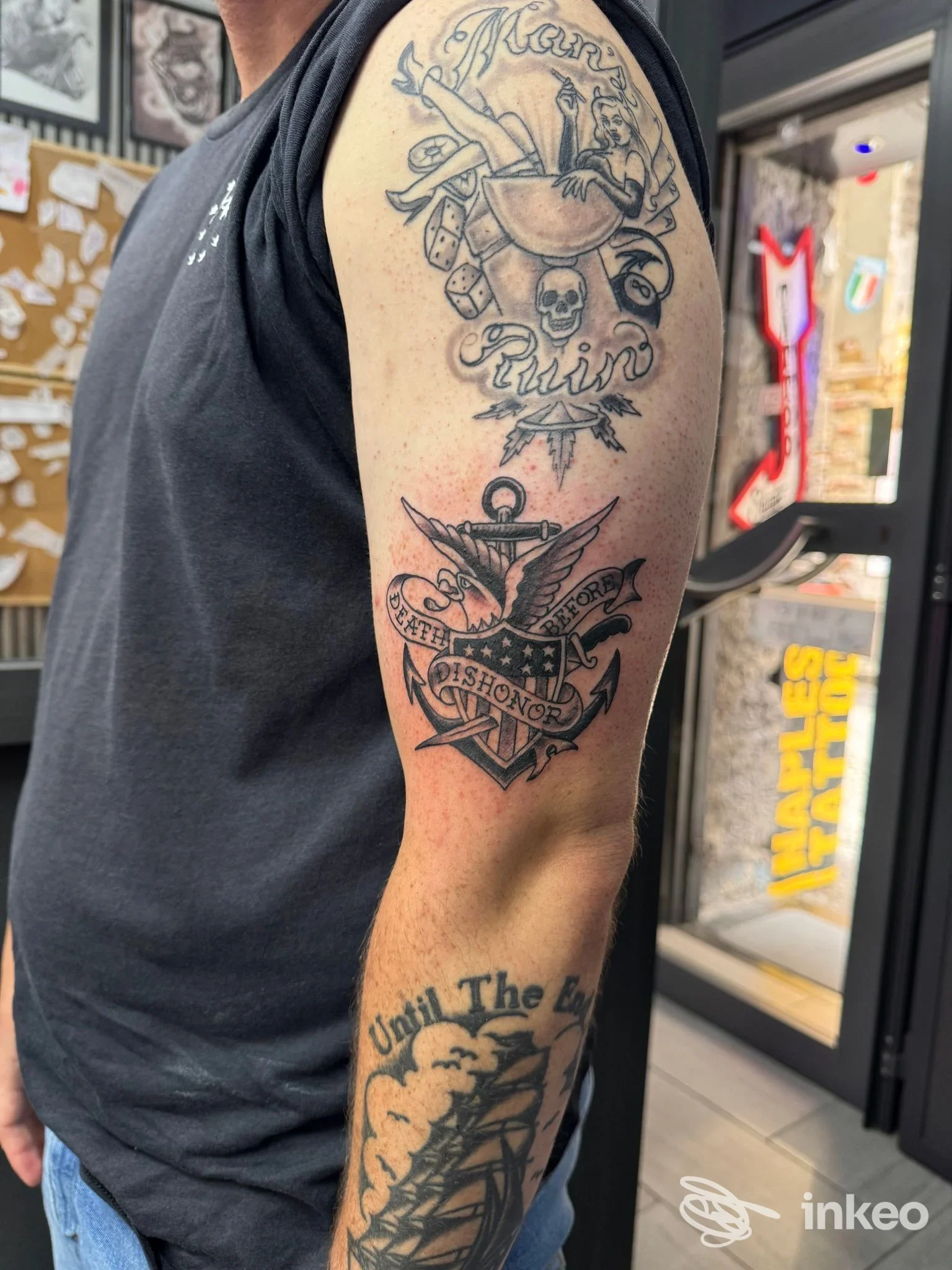 Braccio di un uomo con tatuaggi visibili: due tatuaggi distinti sulla parte superiore del braccio, senza volto visibile, scatto in stile ritratto informale a Napoli.