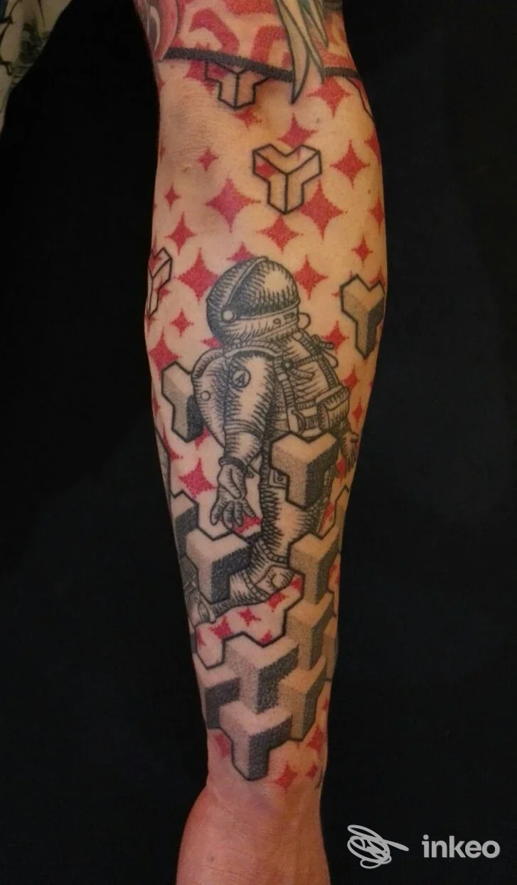 Braccio raffigurante tatuaggio con astronauta e forme geometriche su sfondo a stelle rosse, realizzato nello studio Alessandro Sabatino Tattoo a Pontecagnano Faiano.