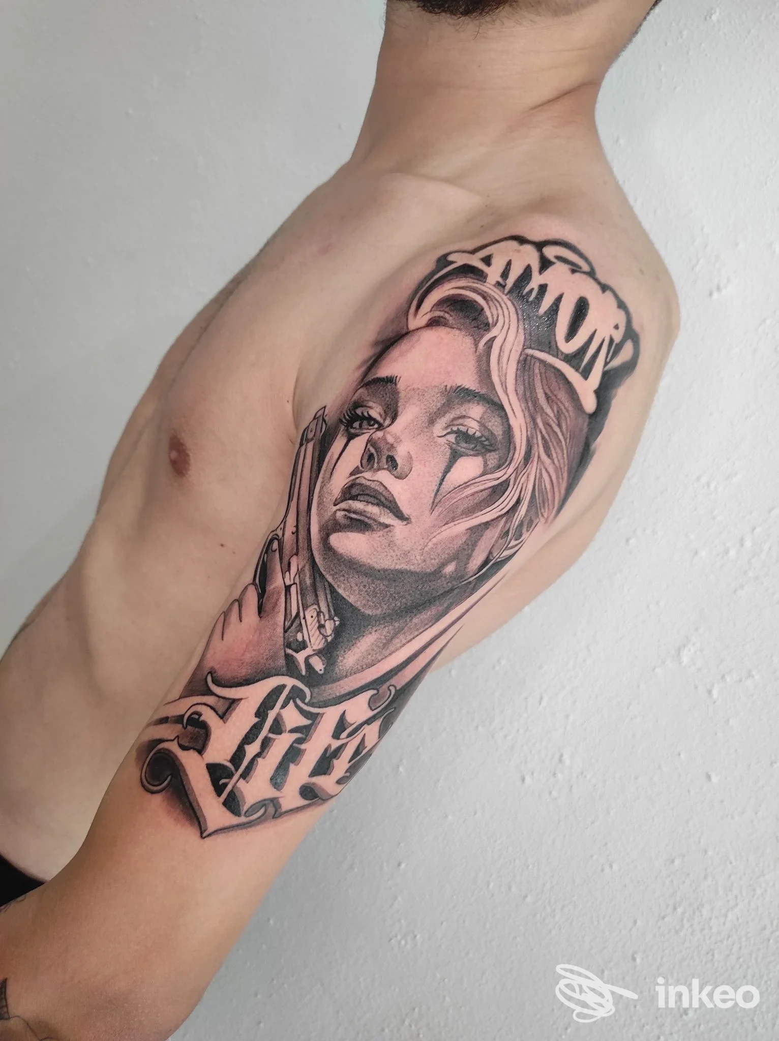 Tattoo sul braccio sinistro realizzato da Thaba Tattoo a Crispano: ritratto femminile in stile realistico con cornici e testo, tatuaggio visibile su pelle reale.
