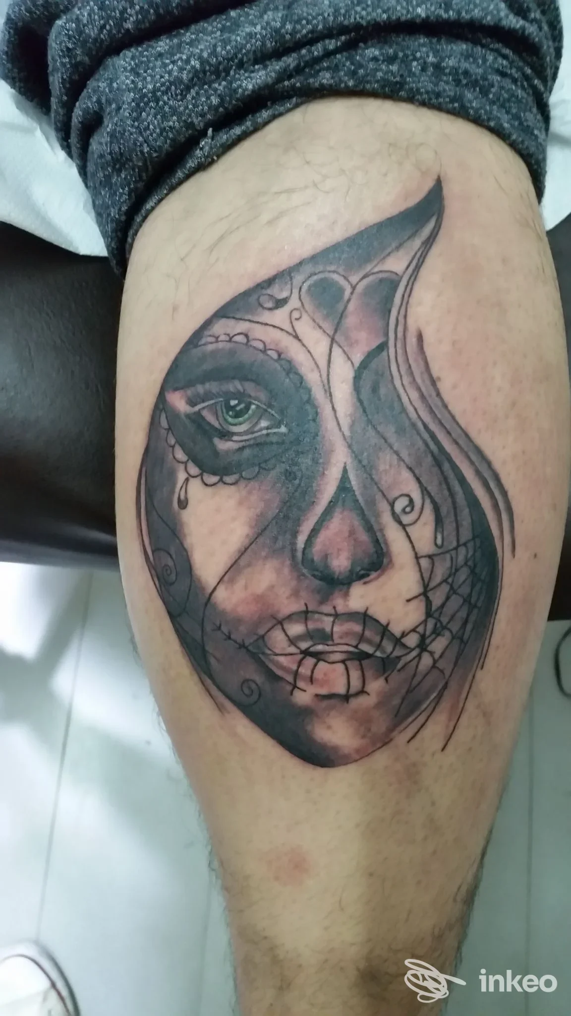 Tatuaggio realistico in bianco e nero su gamba, raffigurante un volto stilizzato con elementi geometrici e pattern. studio Old Style TATTOO SHOP a Caserta.