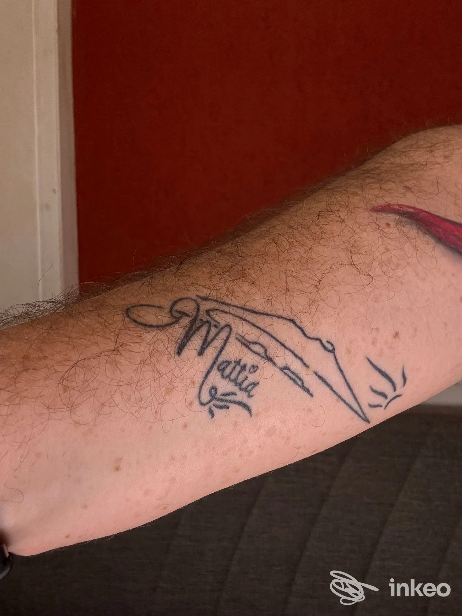 Tattoo visibile sull’avambraccio sinistro: tratto stilizzato di una mano con la parola Mattia, eseguito sulla pelle, senza presenza di volto. Napoli, Little Star Tattoo.