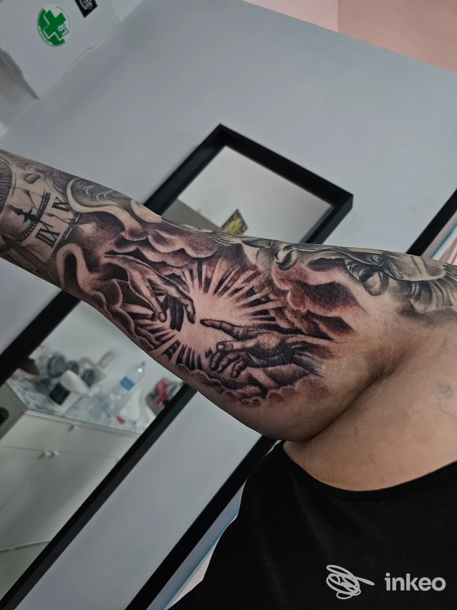 Avambraccio sinistro con un tatuaggio in stile black and gray, motivo radiale di grandi raggi scuri, visible su pelle, scatto interno studio Thisisfrenk a Sperone.