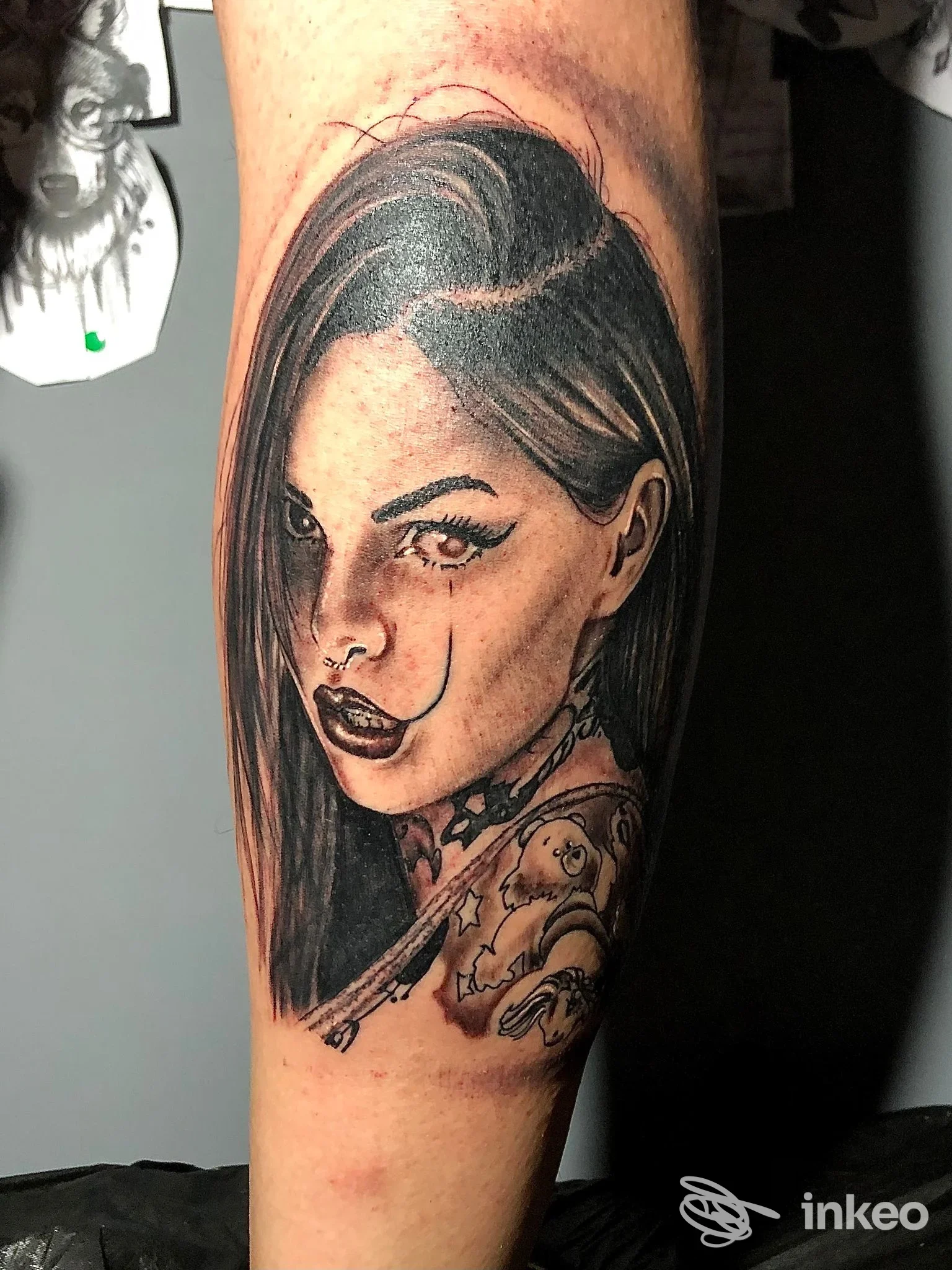 tatuaggio realistico su pelle: ritratto femminile in toni neri e grigi, con dettagli di capelli e tessuto tatuato sul braccio, senza elementi di overlay o foto riutilizzate.